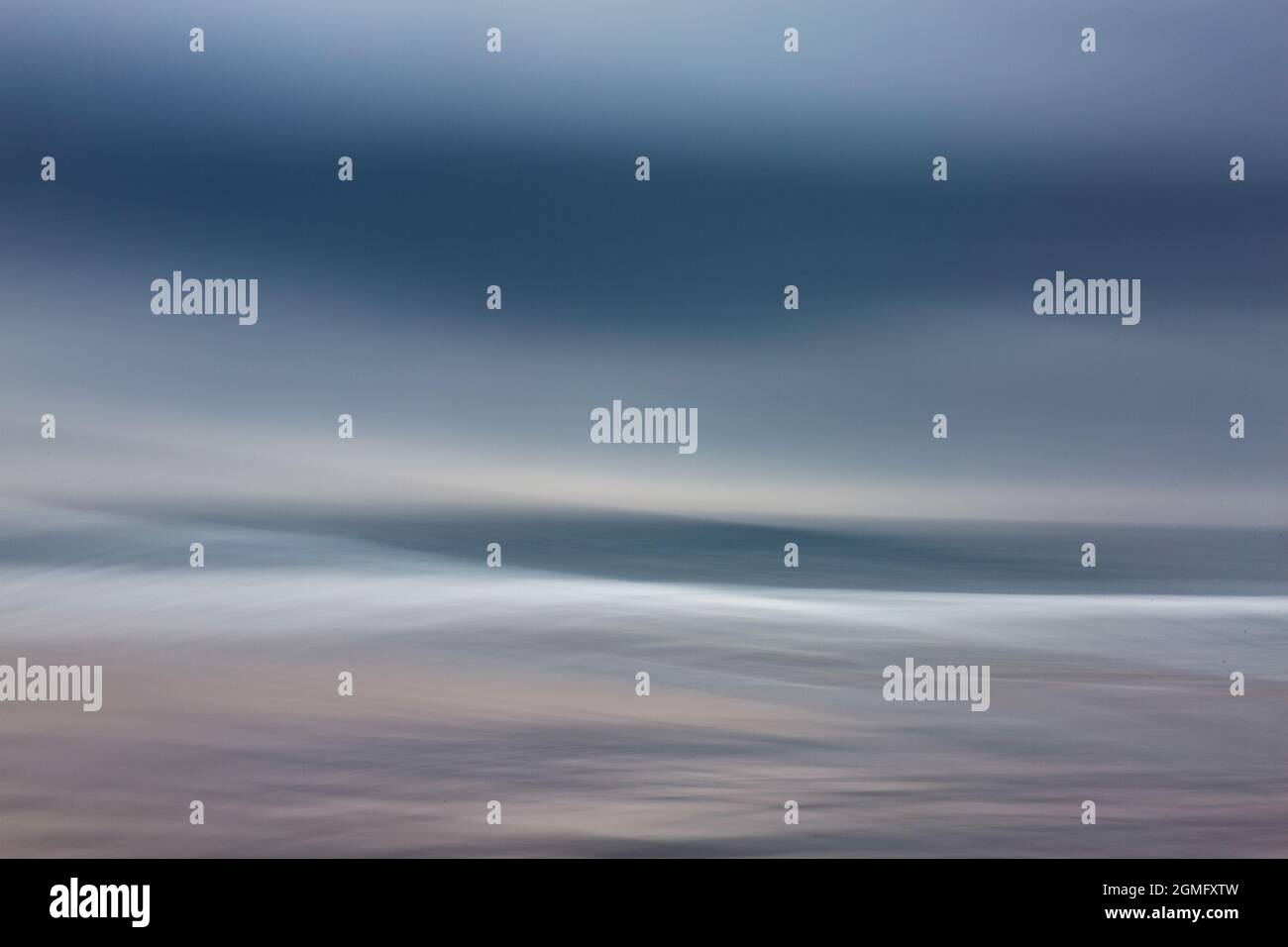 Dreifache Belichtung und absichtliche Kamerabewegungen an einem stürmischen Tag am Warkworth Beach an der Küste von Northumberland. Stockfoto