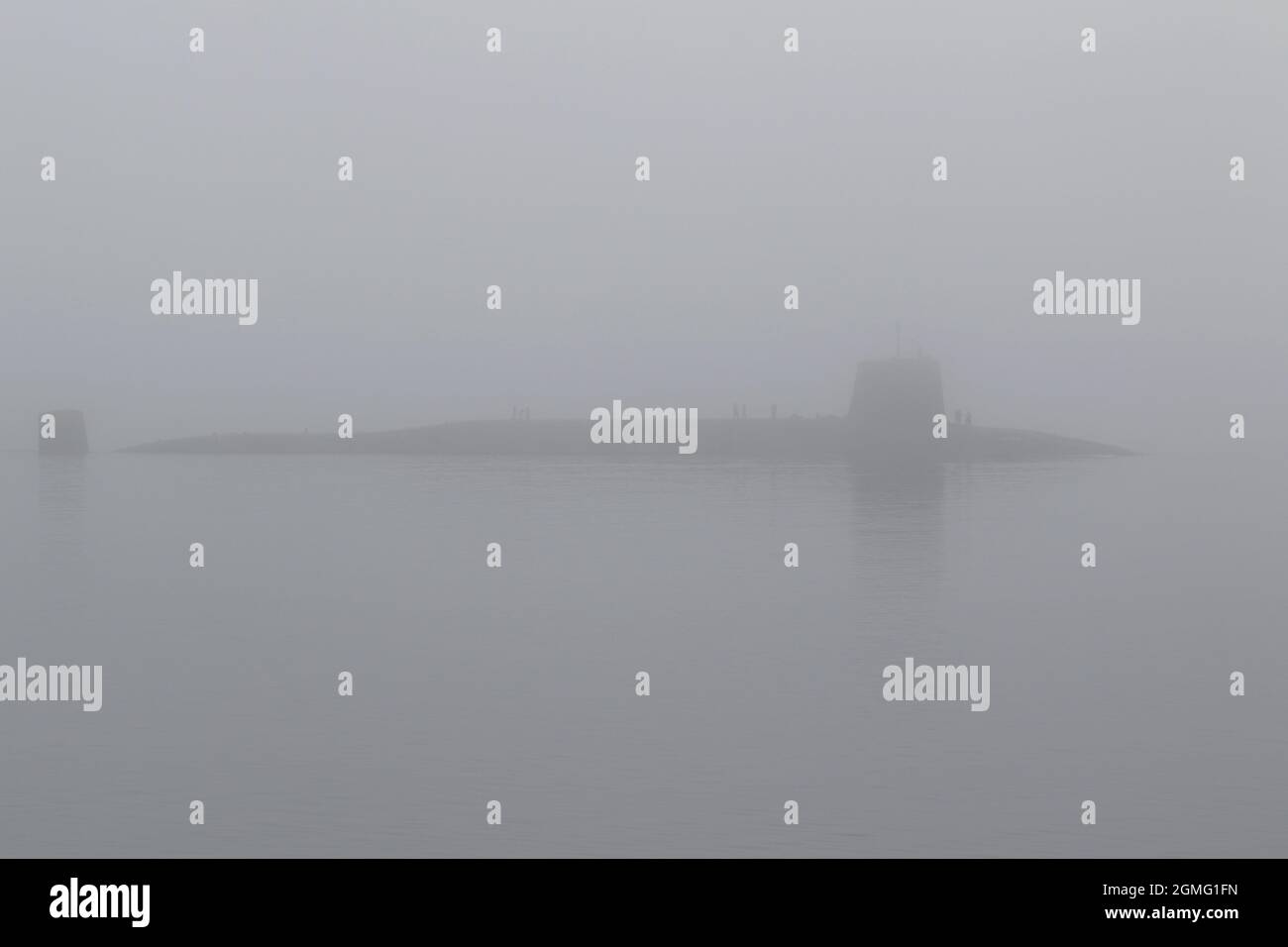 Die unheimliche Silhouette der dreizackigen HMS Vigilant (S30), einem von der Royal Navy betriebenen U-Boot der Vanguard-Klasse, das an einem nebelgebundenen Gourock am Firth of Clyde, Schottland, vorbeiführt. Stockfoto