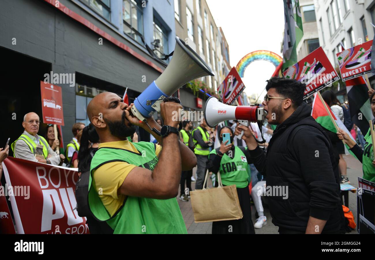 Ein Protestor, der während der Demonstration durch ein Megaphon schreit. Boykott der Puma-Proteste, die von der palästinensischen Solidaritätskampagne und dem FOA (Friends of Al Aqsa) im Flagship-Store von Puma in der Carnaby Street in London organisiert wurden. Stockfoto