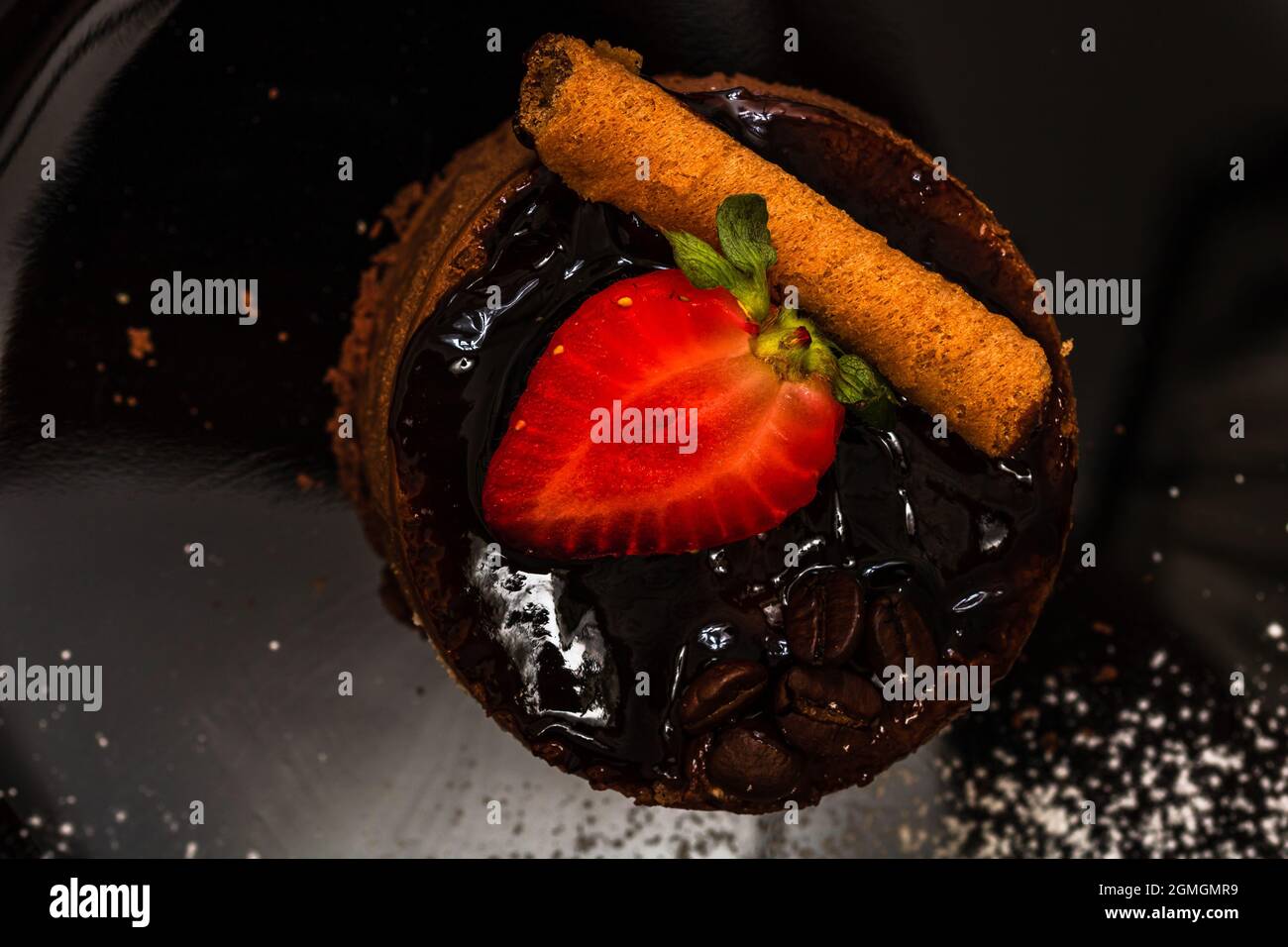 Ein Blick von oben auf Schokoladenmousse Kuchen gekrönt mit Erdbeere und Stockrolle Stockfoto