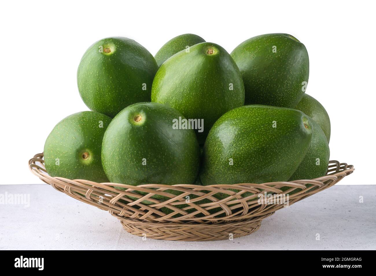 Avocados in einem Korb, auch bekannt als Alligatorbirne oder Butterfrucht, frische Früchte auf weißem Hintergrund, Nahaufnahme Stockfoto