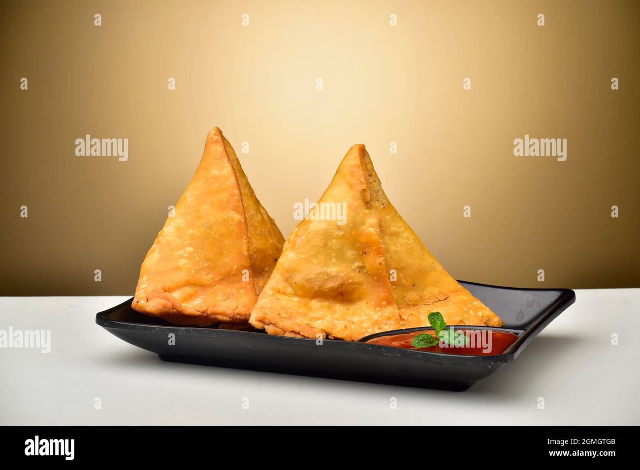 Gefüllte Samosa mit Sauce in Teller Stockfoto