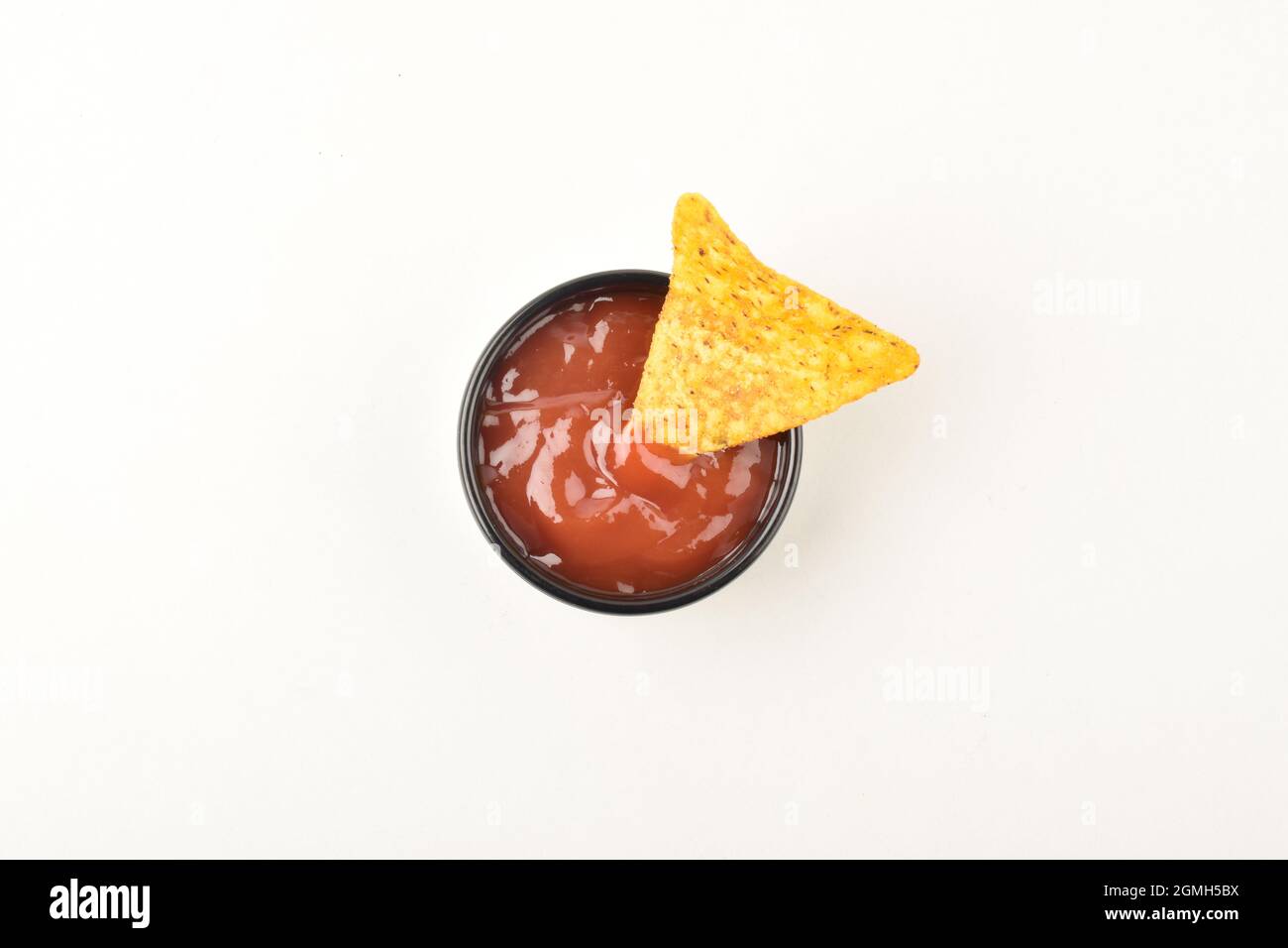 Tortilla Chips in Sauce auf weißem Hintergrund getaucht Stockfoto