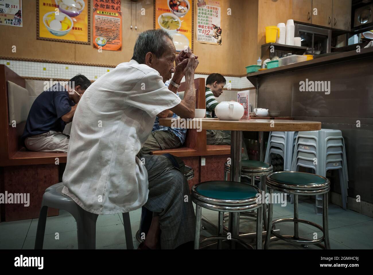 Ein alter Mann wartet in einem Restaurant in Yuen Long, New Territories, Hongkong, auf sein Essen Stockfoto