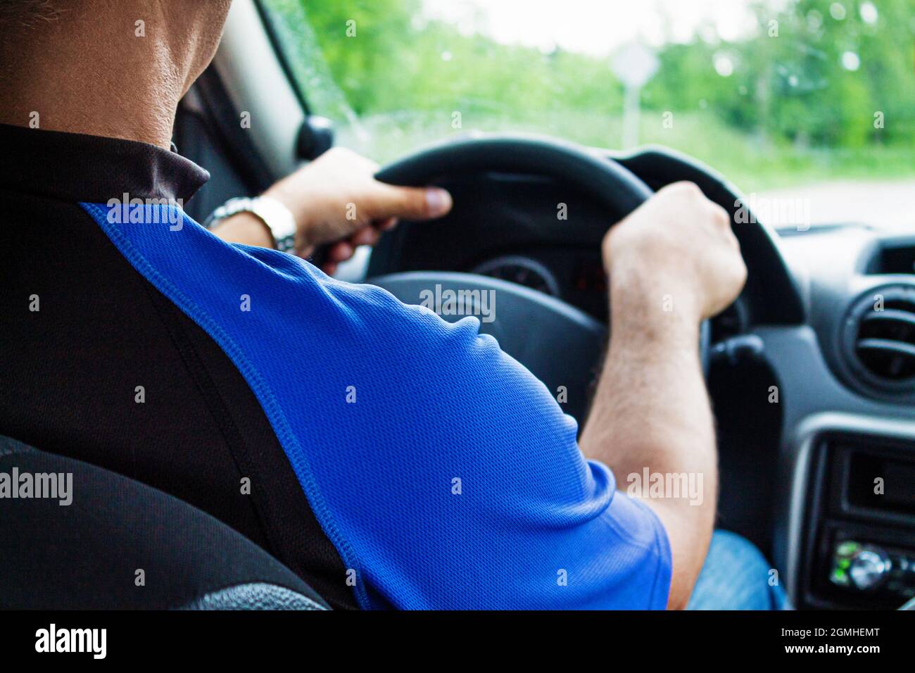 Ein Mann sitzt in einem Auto hinter dem Lenkrad Nahaufnahme. Reisen, Reisen. Stockfoto