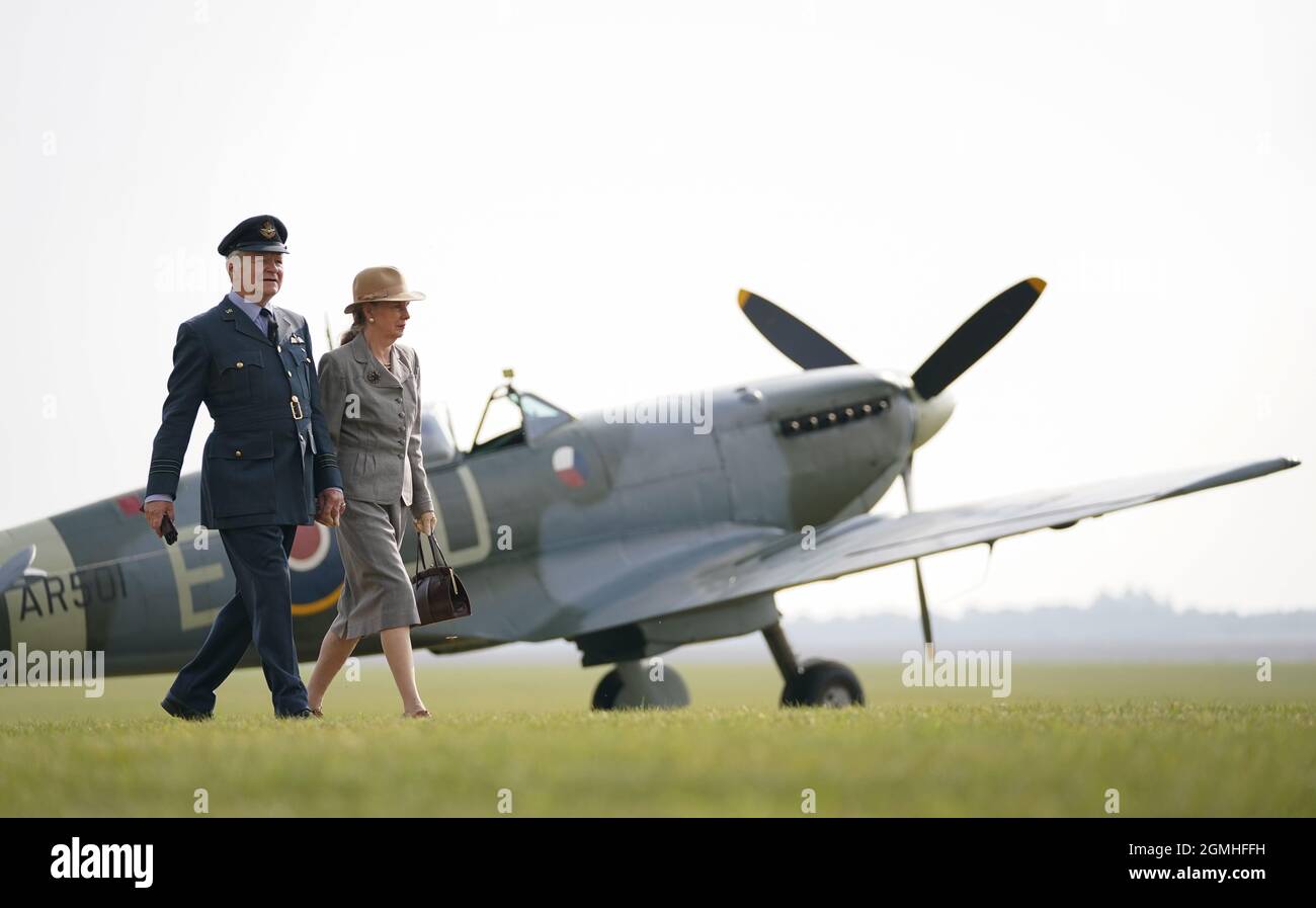 Moriarty und Sheila von RAF Ops 39-45 Living History Group laufen während der Battle of Britain Air Show im IWM Duxford an einer Spitfire auf der Fluglinie vorbei. Bilddatum: Sonntag, 19. September 2021. Stockfoto