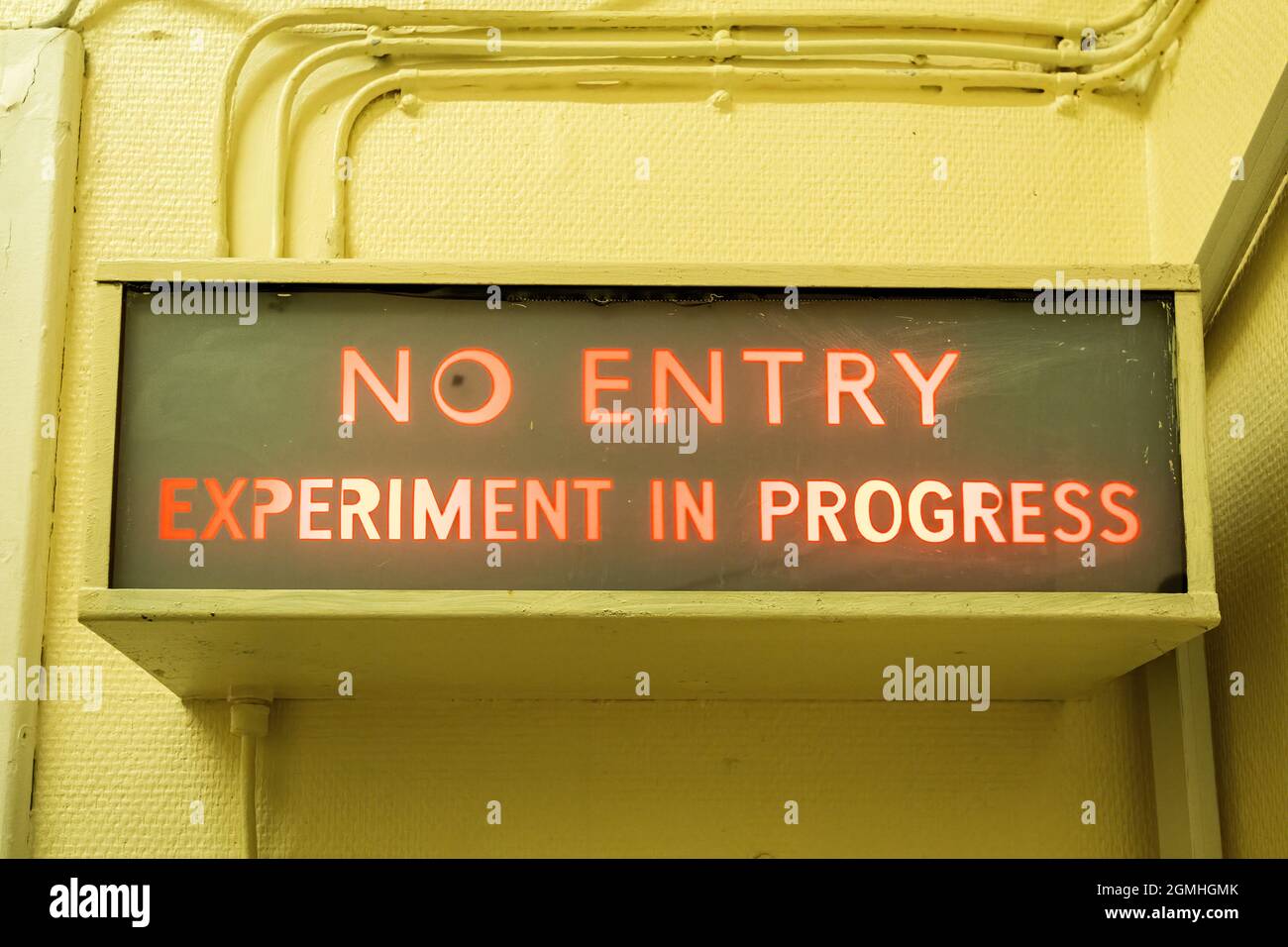 Warnschild „No entry Experiment in progress“ in einem Labor leuchtet rot Stockfoto