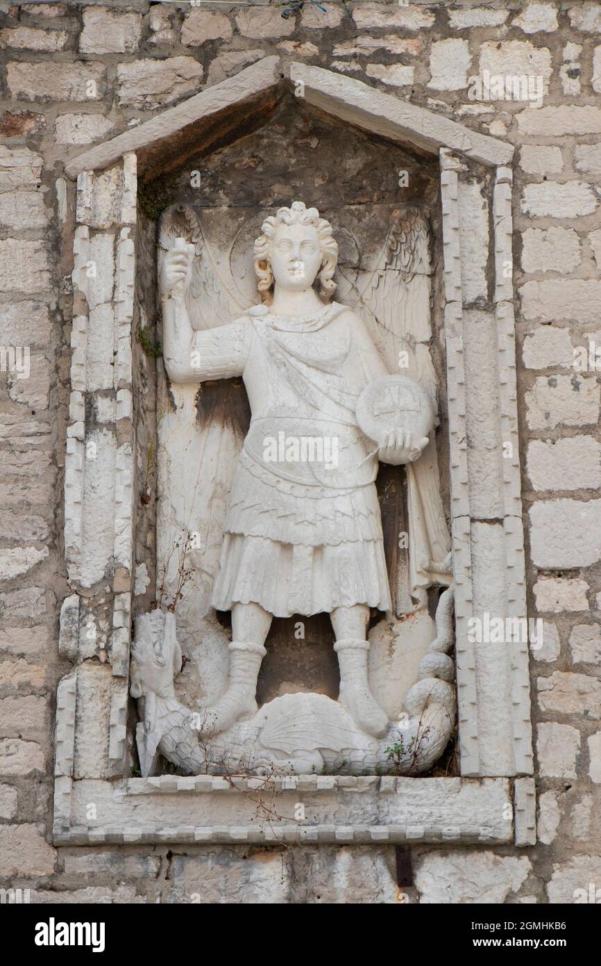 Sibenik, Kroatien - 25. August 2021: Steinskulptur des heiligen Erzengels Michael, der einen Drachen tötete, Detail auf dem Gebäude der öffentlichen Bibliothek aus Stein und Glas Stockfoto
