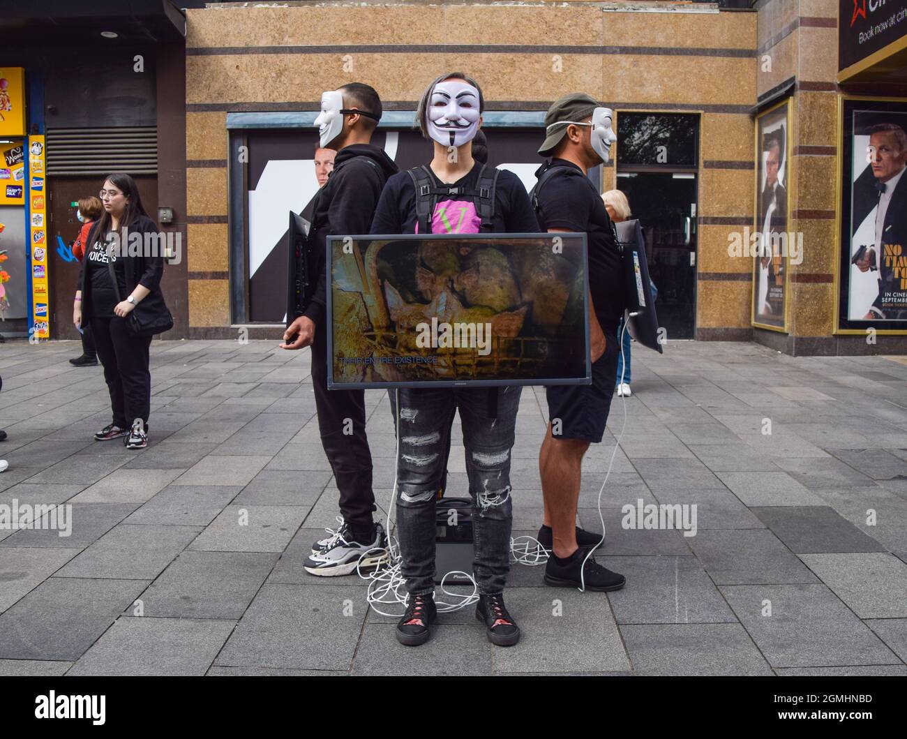 London, Großbritannien. September 2021. Aktivisten, die Guy Fawkes Masken tragen, stehen mit Bildschirmen, auf denen grafische Videos von Tieren gezeigt werden, die während der veganen Kampagne auf dem Leicester Square für Lebensmittel getötet wurden. Die Passanten werden ermutigt, vegan zu sein, indem grafische Aufnahmen der Schrecken gezeigt werden, die Tiere in Schlachthöfen, in der Tierzucht und in der Fischwirtschaft durchmachen. Kredit: SOPA Images Limited/Alamy Live Nachrichten Stockfoto