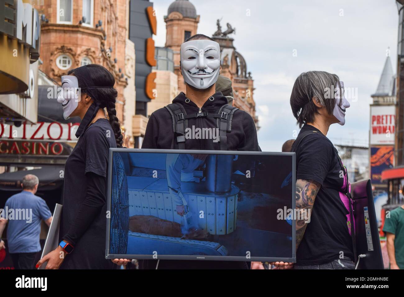 London, Großbritannien. September 2021. Aktivisten, die Guy Fawkes Masken tragen, stehen mit Bildschirmen, auf denen grafische Videos von Tieren gezeigt werden, die während der veganen Kampagne auf dem Leicester Square für Lebensmittel getötet wurden. Die Passanten werden ermutigt, vegan zu sein, indem grafische Aufnahmen der Schrecken gezeigt werden, die Tiere in Schlachthöfen, in der Tierzucht und in der Fischwirtschaft durchmachen. Kredit: SOPA Images Limited/Alamy Live Nachrichten Stockfoto