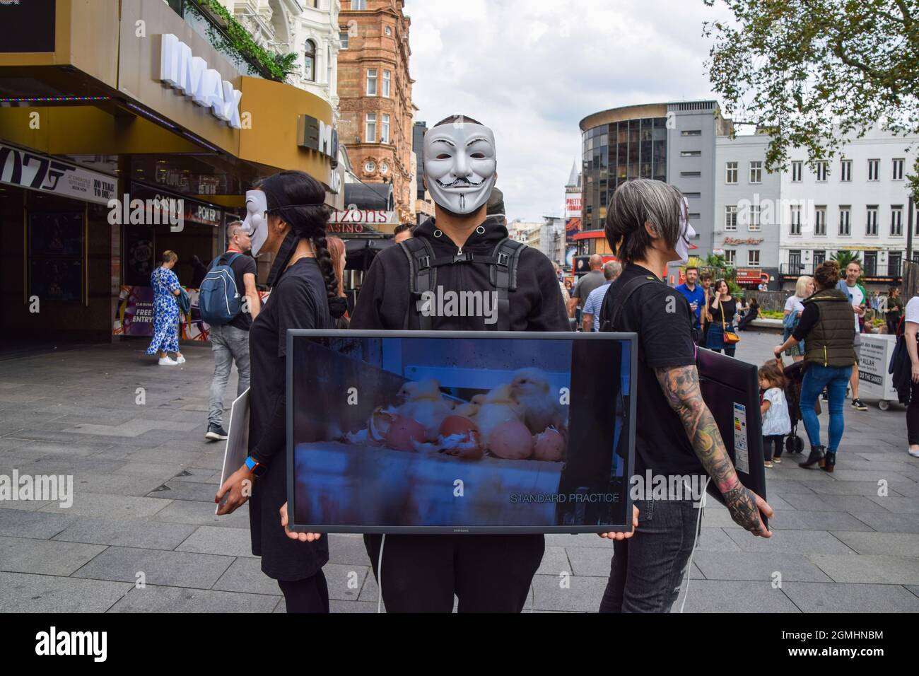 London, Großbritannien. September 2021. Aktivisten, die Guy Fawkes Masken tragen, stehen mit Bildschirmen, auf denen grafische Videos von Tieren gezeigt werden, die während der veganen Kampagne auf dem Leicester Square für Lebensmittel getötet wurden. Die Passanten werden ermutigt, vegan zu sein, indem grafische Aufnahmen der Schrecken gezeigt werden, die Tiere in Schlachthöfen, in der Tierzucht und in der Fischwirtschaft durchmachen. Kredit: SOPA Images Limited/Alamy Live Nachrichten Stockfoto
