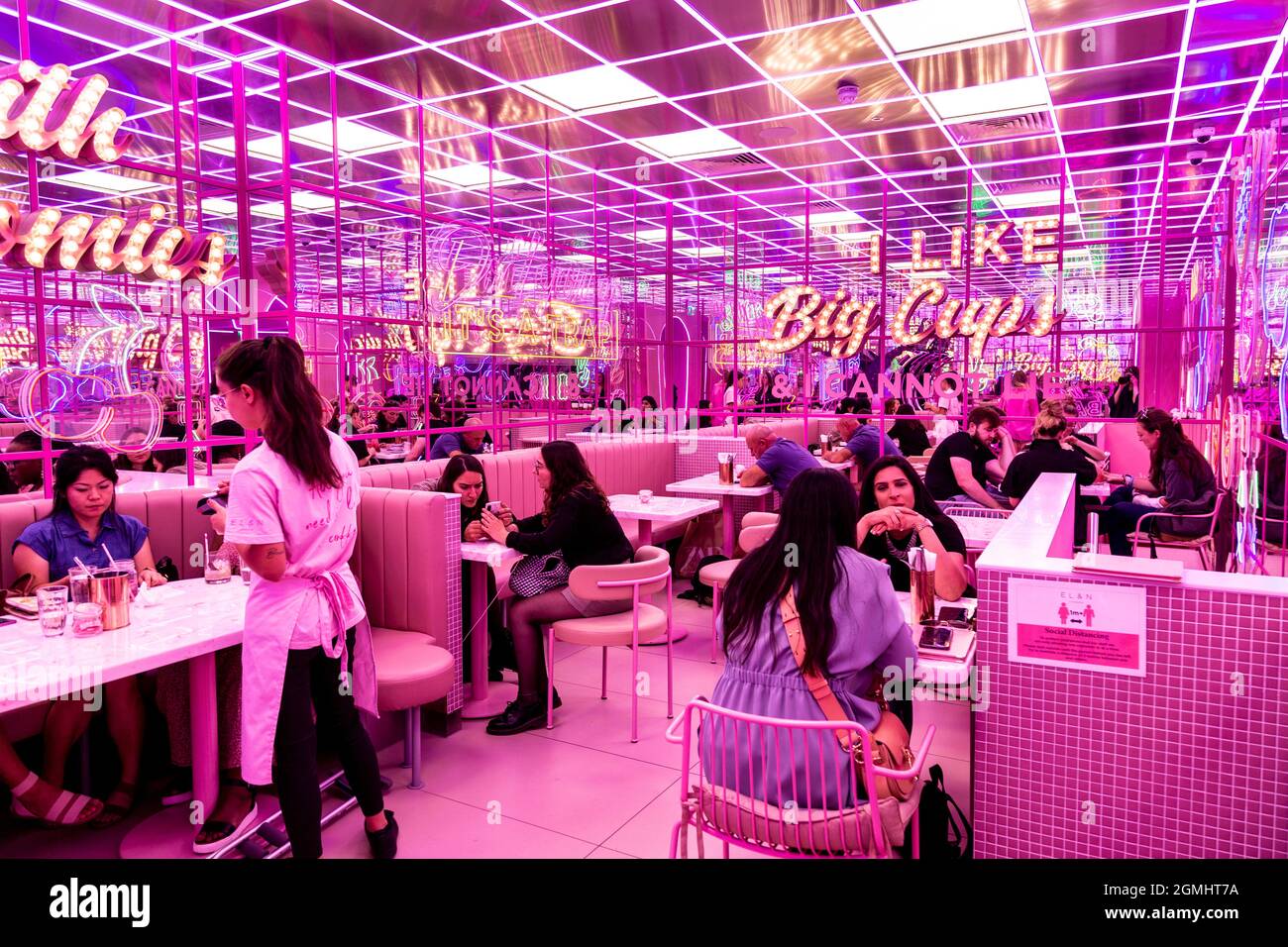 Im El&N Soho Café, London, Großbritannien, befindet sich ein in Retro verspiegeltes, pinkfarbenes Interieur mit Markelampen Stockfoto