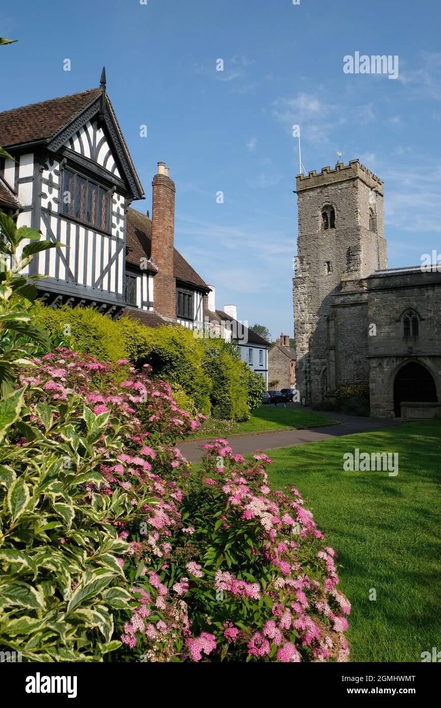 Der normannische Turm der Holy Trinity Parish Church, rechts, und die alte Guildhall, links, in Much Wenlock, Shropshire, England, VEREINIGTES KÖNIGREICH Stockfoto
