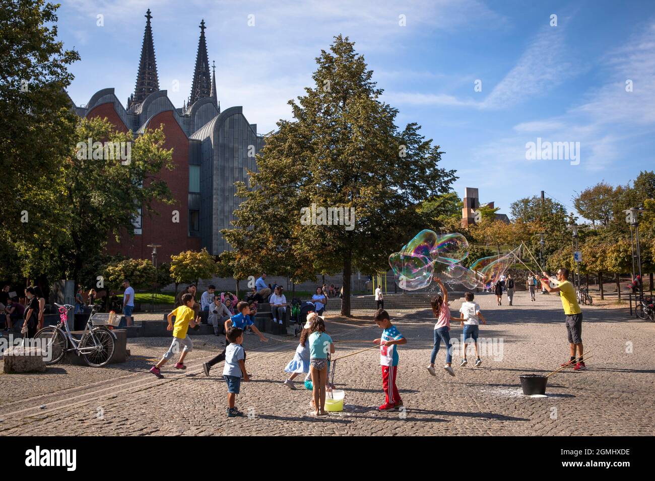 Der Mensch macht riesige Seifenblasen im Rheingarten in der Altstadt, der Katehdral, Köln, Deutschland. Mann macht grosse Seifenblasen im Rhein Stockfoto