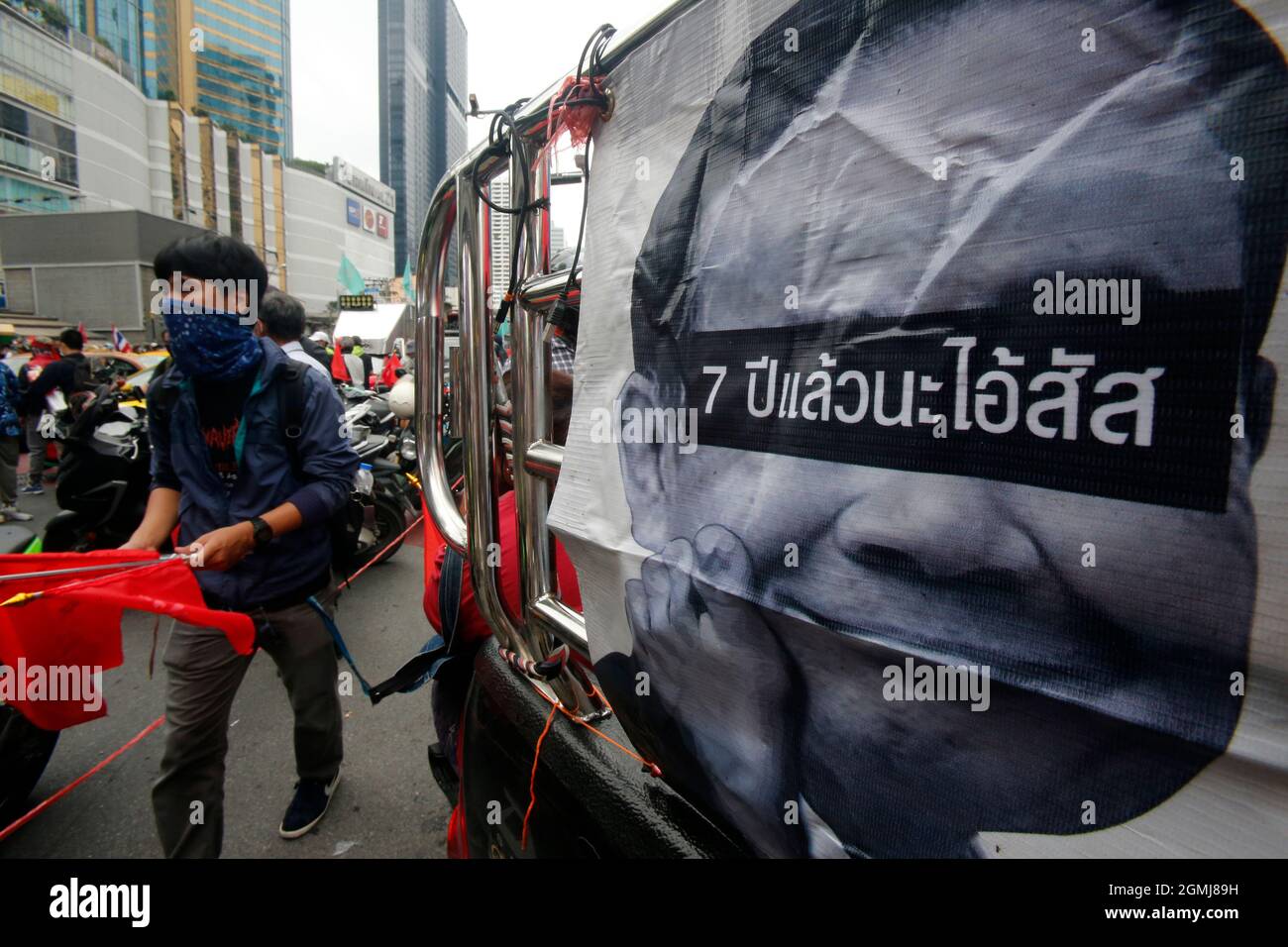 Ein Protestler, der eine Gesichtsmaske trägt, Geht an einem Foto des thailändischen Premierministers Prayuth Chan O-Cha vorbei, während eine Demonstration von Automob stattfand.Mehr als 1,000 Autos und Motorräder fuhren bei starkem Regen von der Kreuzung Asoke ab, um an einer Kundgebung des 'Automob' teilzunehmen, die sich in einem weiteren Versuch durch die Straßen der Hauptstadt winden soll Um Premierminister Prayut Chan-o-cha zu verdrängen. Die Demonstration fand im Zusammenhang mit dem 15. Jahrestag des Putsches vom 19. September 2006 statt, der Premierminister Thaksin Shinawatra verdrängte. Darauf folgte der Staatsstreich vom 22. Mai 2014, der den Beginn des l von Gen Prayut Chan-o-cha markierte Stockfoto