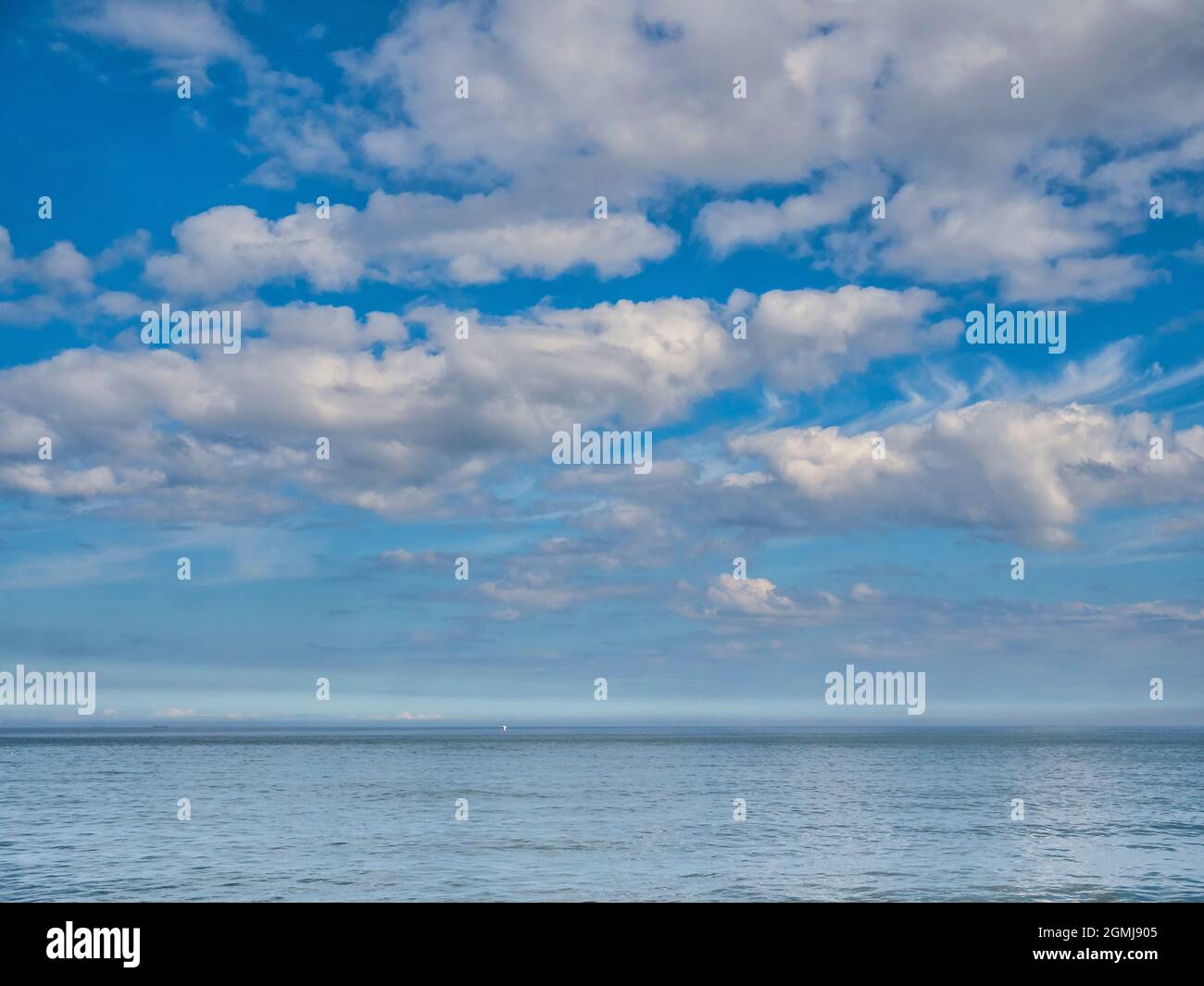 Ruhige Wolkenlandschaft mit flauschigen Kumuluswolken, die vom Wellenbrecher-Steg am Eingang zum Whitby Harbour über die Nordsee blicken Stockfoto