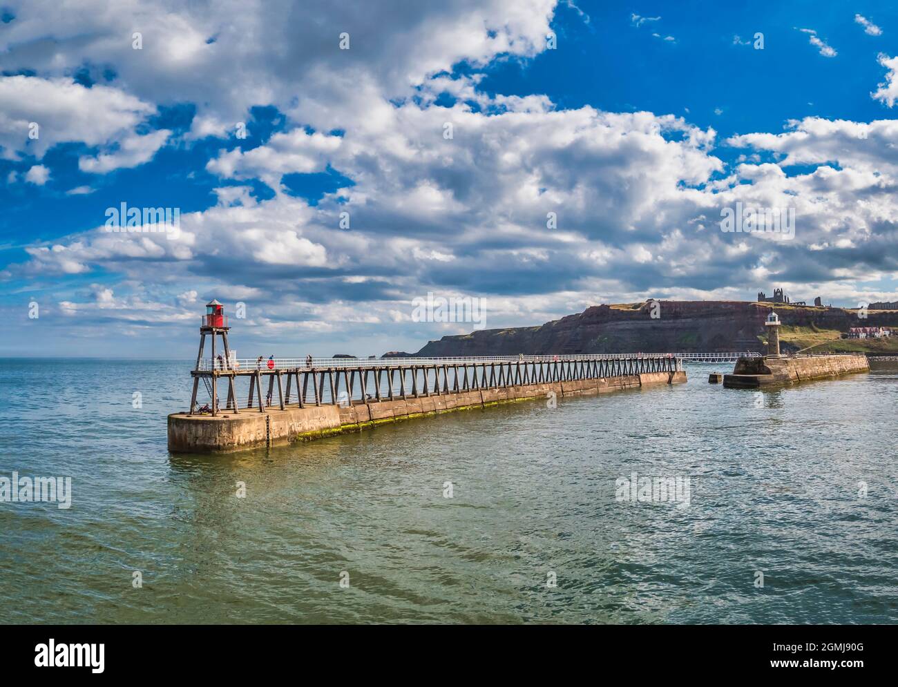 Malerisches Whitby mit Blick über den Wellenbrecher zur Nordsee mit der Kirche St. Mary und der Whitby Abbey in weiter Ferne Stockfoto