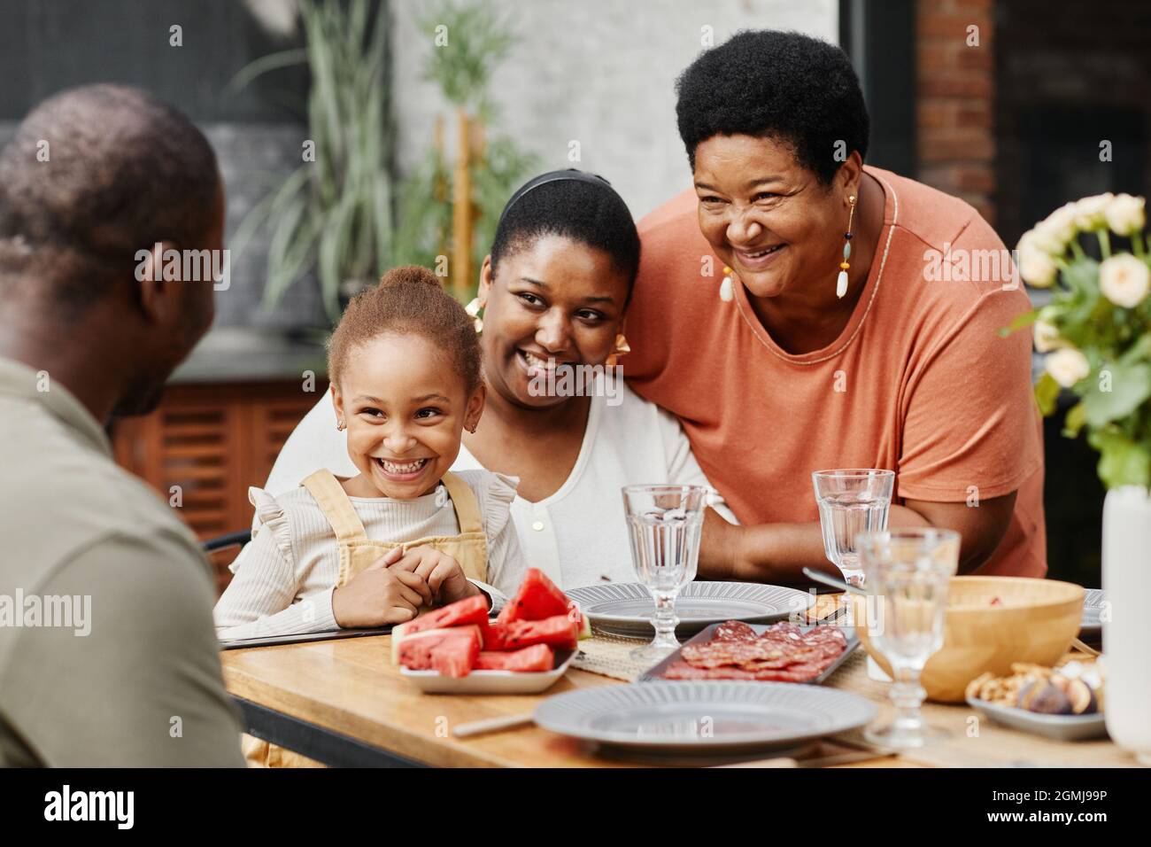 Porträt einer glücklichen afroamerikanischen Familie, die gemeinsam auf der Terrasse im Freien zu Abend gegessen hat, Platz zum Kopieren Stockfoto