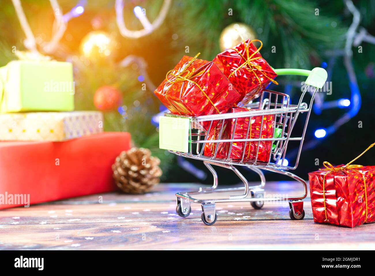 Mini-Warenkorb mit roten weihnachtsgeschenken auf dem Hintergrund des weihnachtsbaums Stockfoto