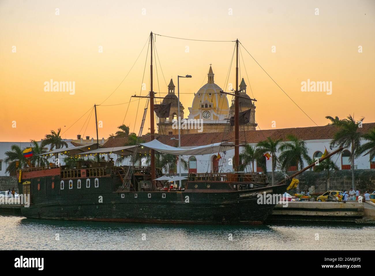 Ein hölzernes Partyschiff im Hafen von Cartagena, Kolumbien, mit der Kathedrale im Hintergrund Stockfoto