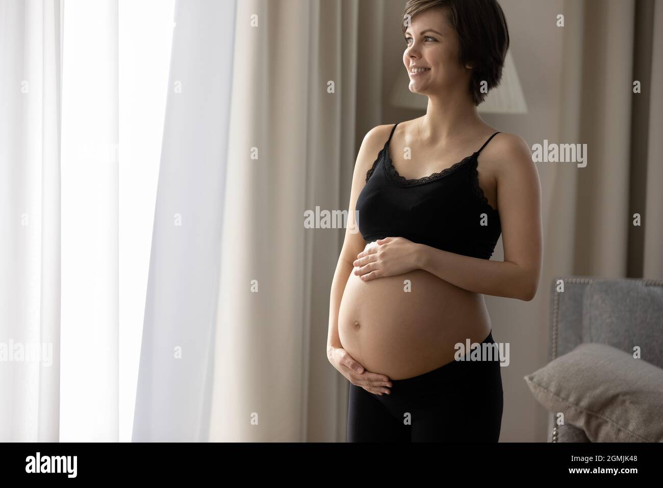 Zukünftige Mutter mit fortgeschrittenen Schwangerschaft Blick weit weg genießen Vorfreude Stockfoto