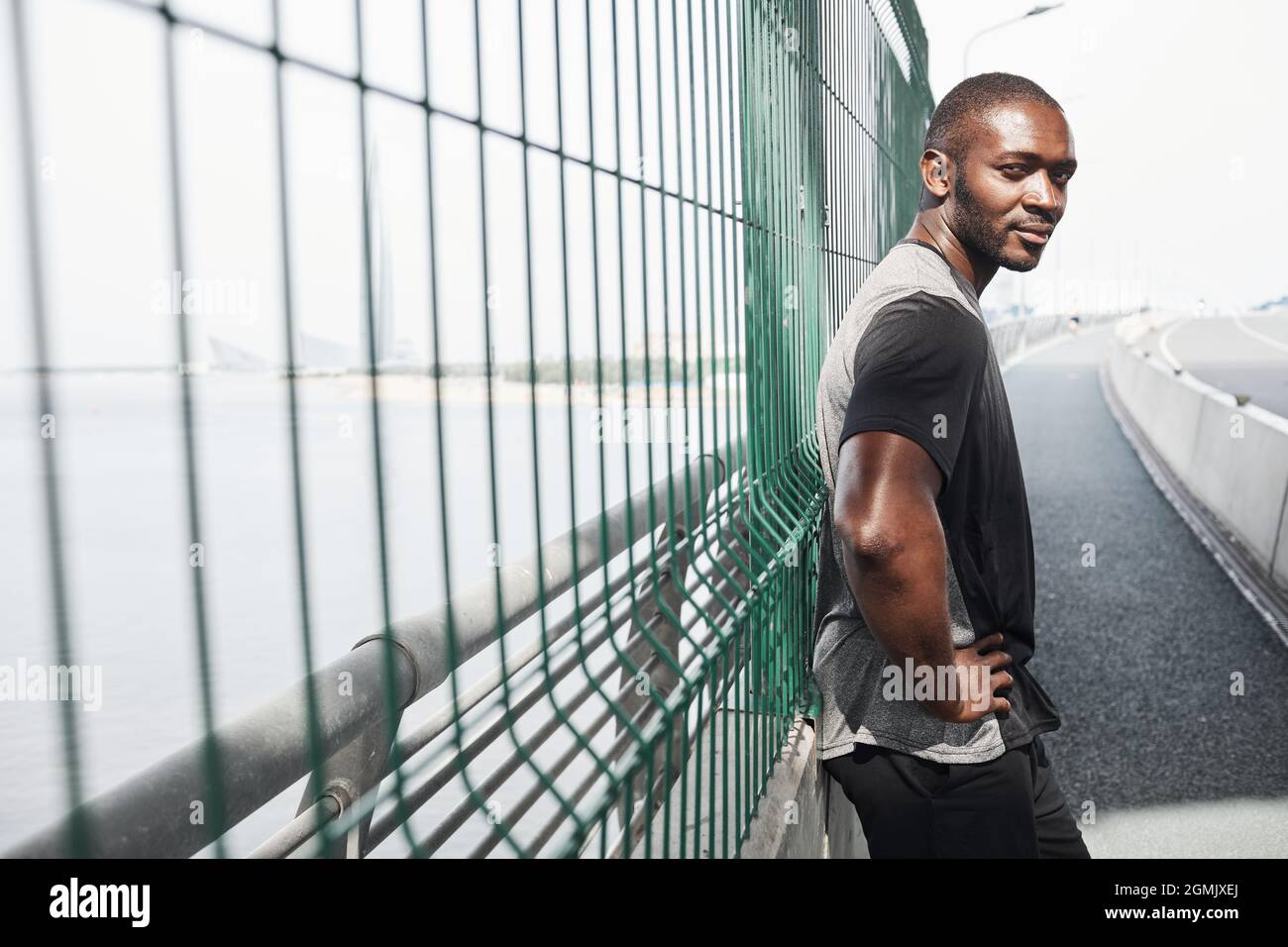 Porträt eines afrikanischen muskulösen Mannes, der auf die Kamera schaut, während er auf einem Sportstadion steht Stockfoto