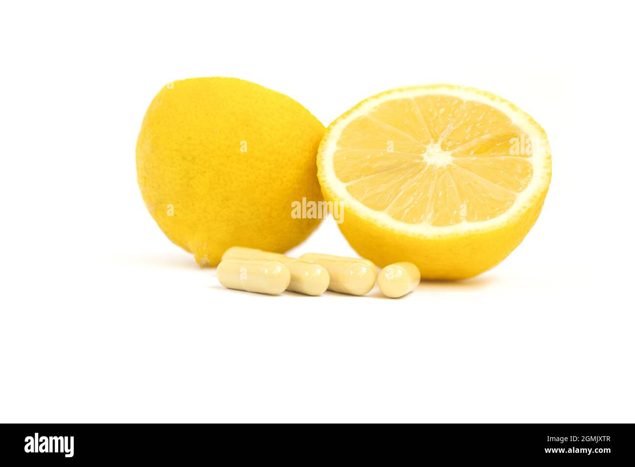Vitaminkapseln. Vitamin C Pillen und gelbe Zitrone auf weißem Hintergrund. Stockfoto