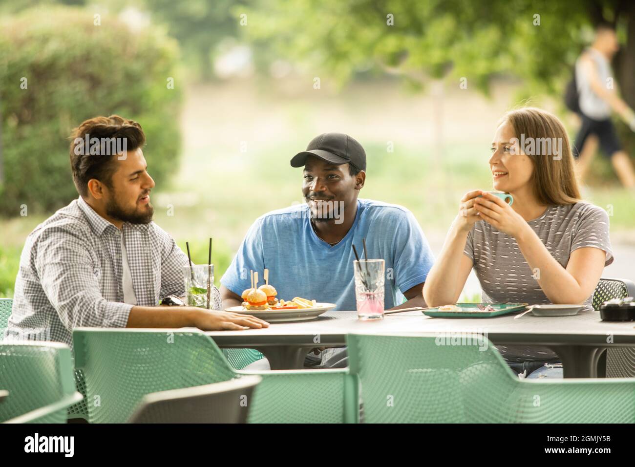 Fröhliche junge Freunde, die Spaß haben, während sie in einem Café reden Stockfoto