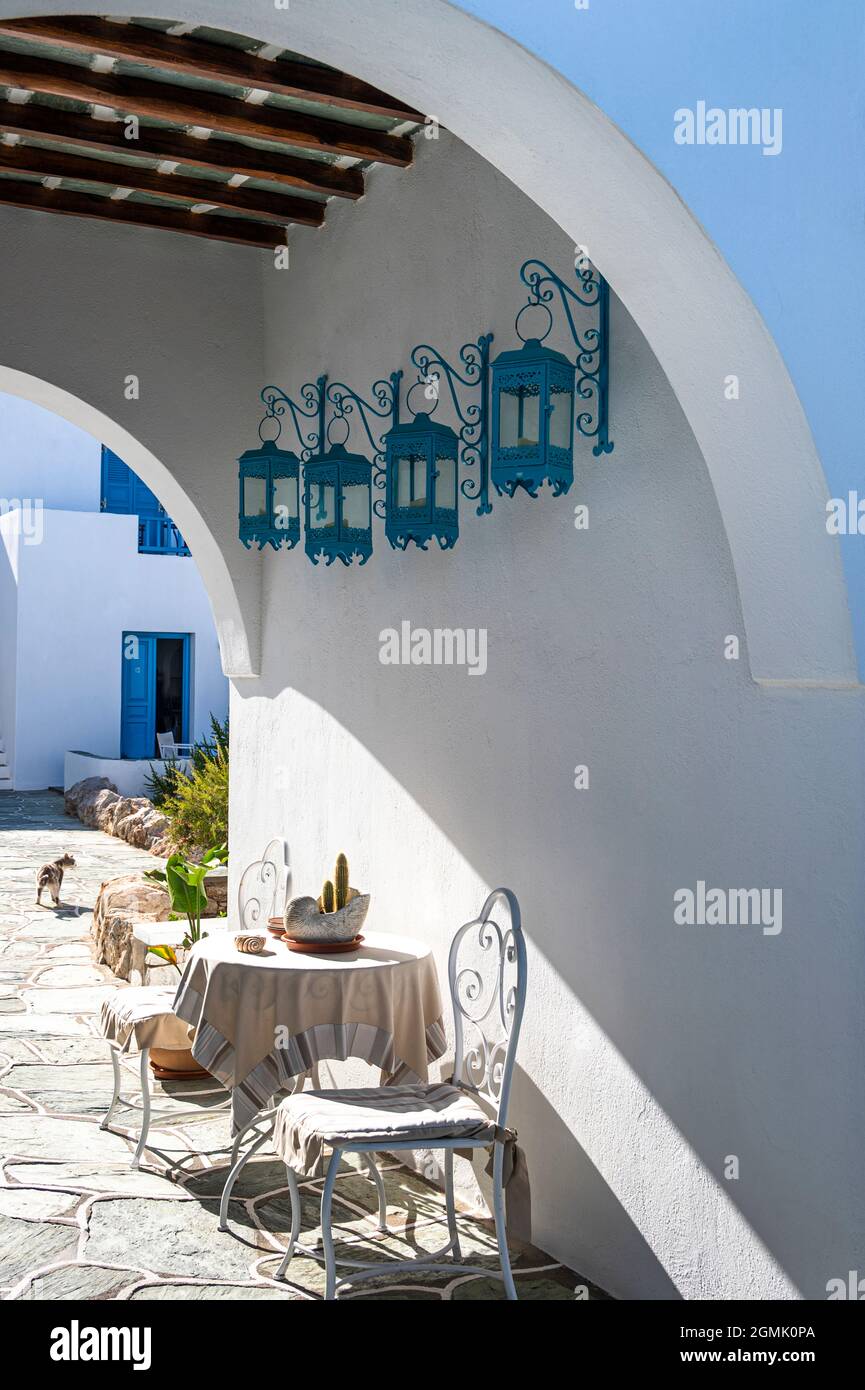 Torbogen führt zu einem Hotelbereich in Chora, Folegandros, Griechenland, der im Sommer einen schattigen Sitzbereich für Hotelgäste bietet Stockfoto
