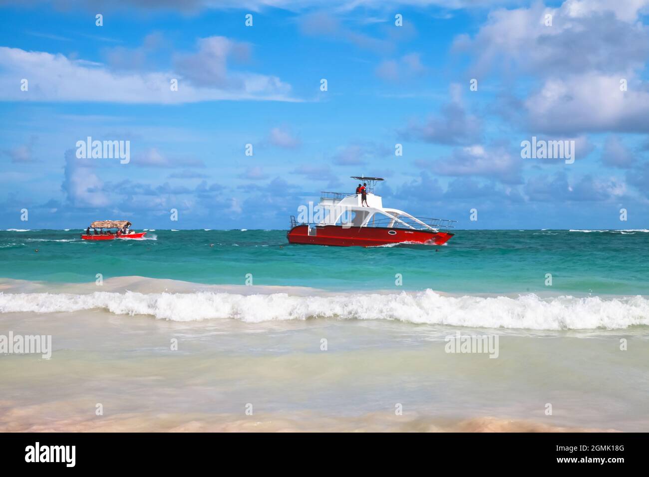 Karibische Küstenlandschaft mit rotem Motorboot, Dominikanische republik. Bavaro Strand Stockfoto
