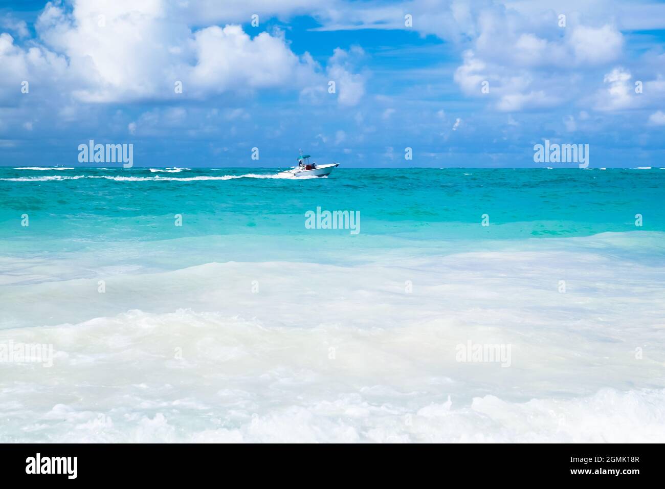 Karibische Küstenlandschaft mit weißem Motorboot, Dominikanische republik. Bavaro Strand Stockfoto