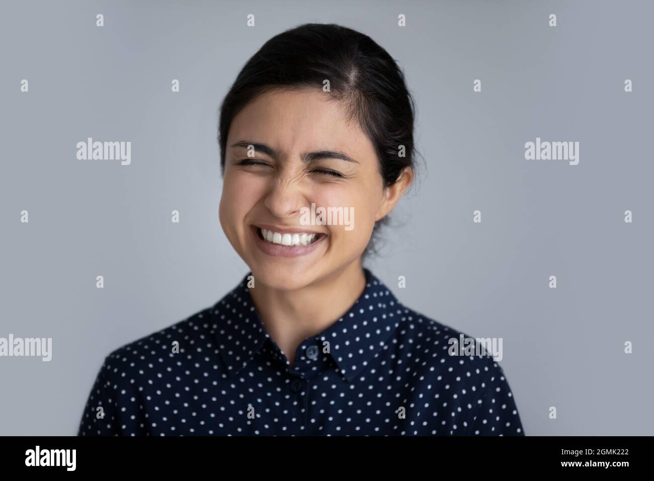 Kopf Schuss aufgeregt indische Frau lachend auf grauen Studio-Hintergrund Stockfoto