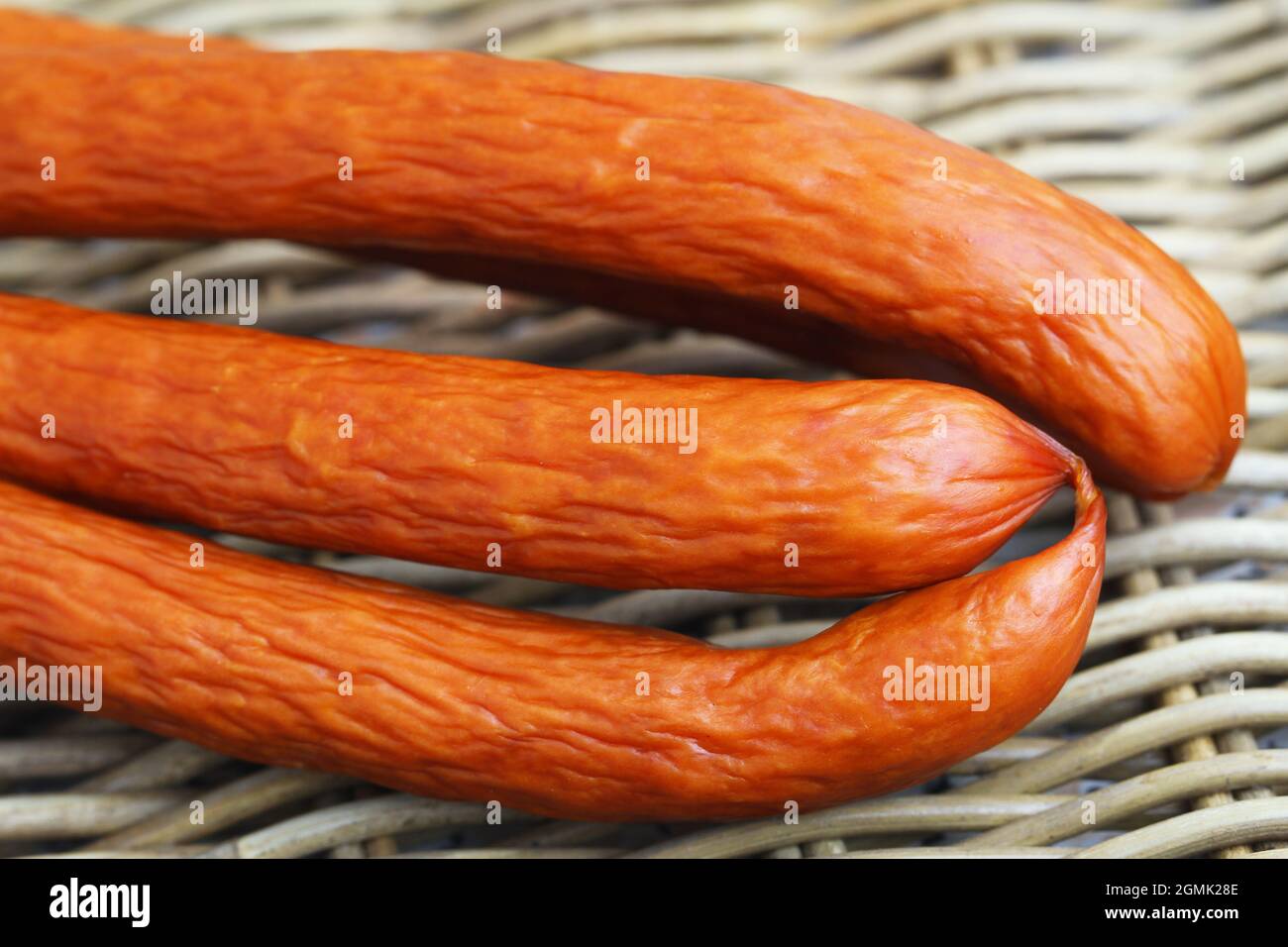 Traditionelle polnische Räucherwurst namens Kabanos auf Korbfleisch, Nahaufnahme Stockfoto