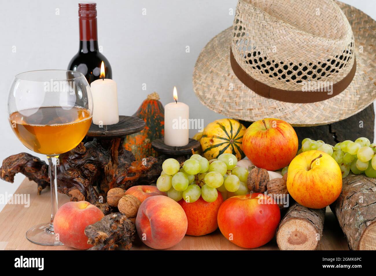 Ein herbstliches Stillleben mit Früchten, Hut und Wein Stockfoto