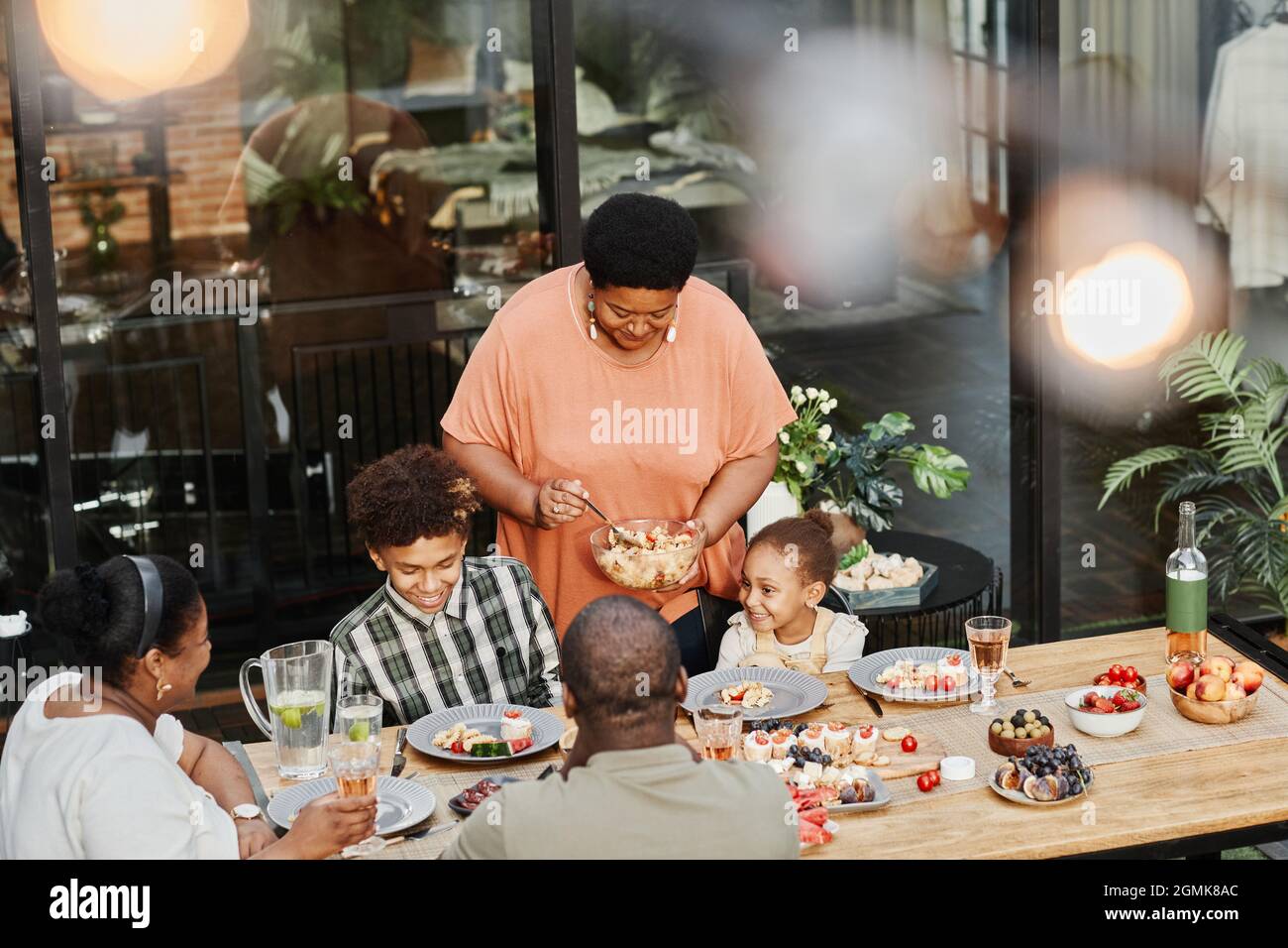 Porträt einer älteren afroamerikanischen Oma, die beim Familienessen im Freien Essen serviert, Kopierbereich Stockfoto