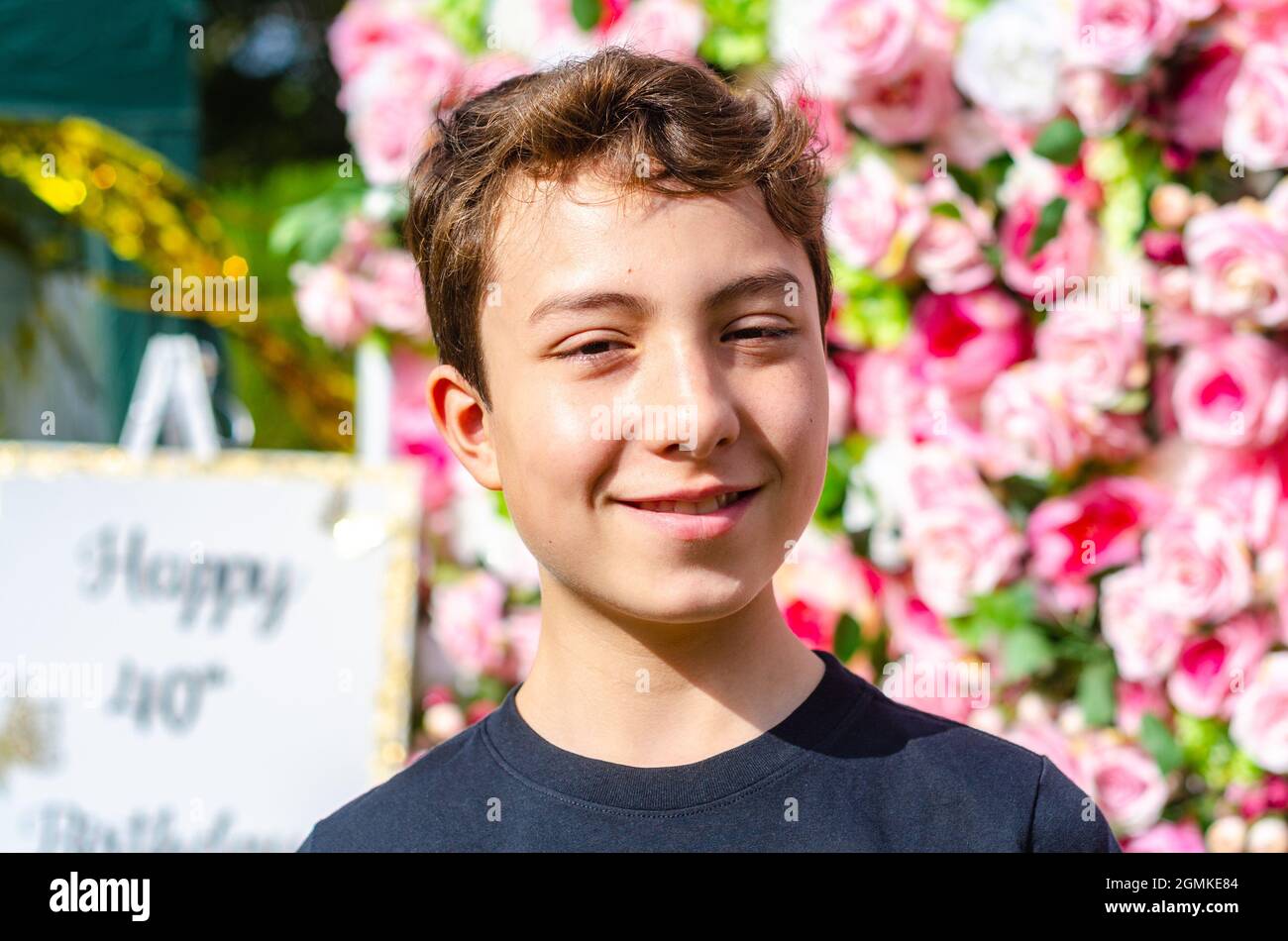 Ein Porträt eines Jungen, der auf einen langsameren Wandhintergrund geschossen wurde. Stockfoto