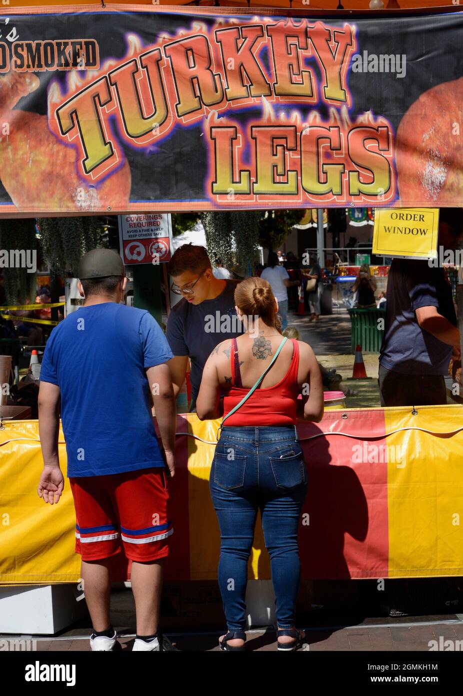 Kunden kaufen geräucherte putenbeine bei einem Lebensmittelhändler auf der jährlichen Fiesta de Santa Fe in Santa Fe, New Mexico. Stockfoto