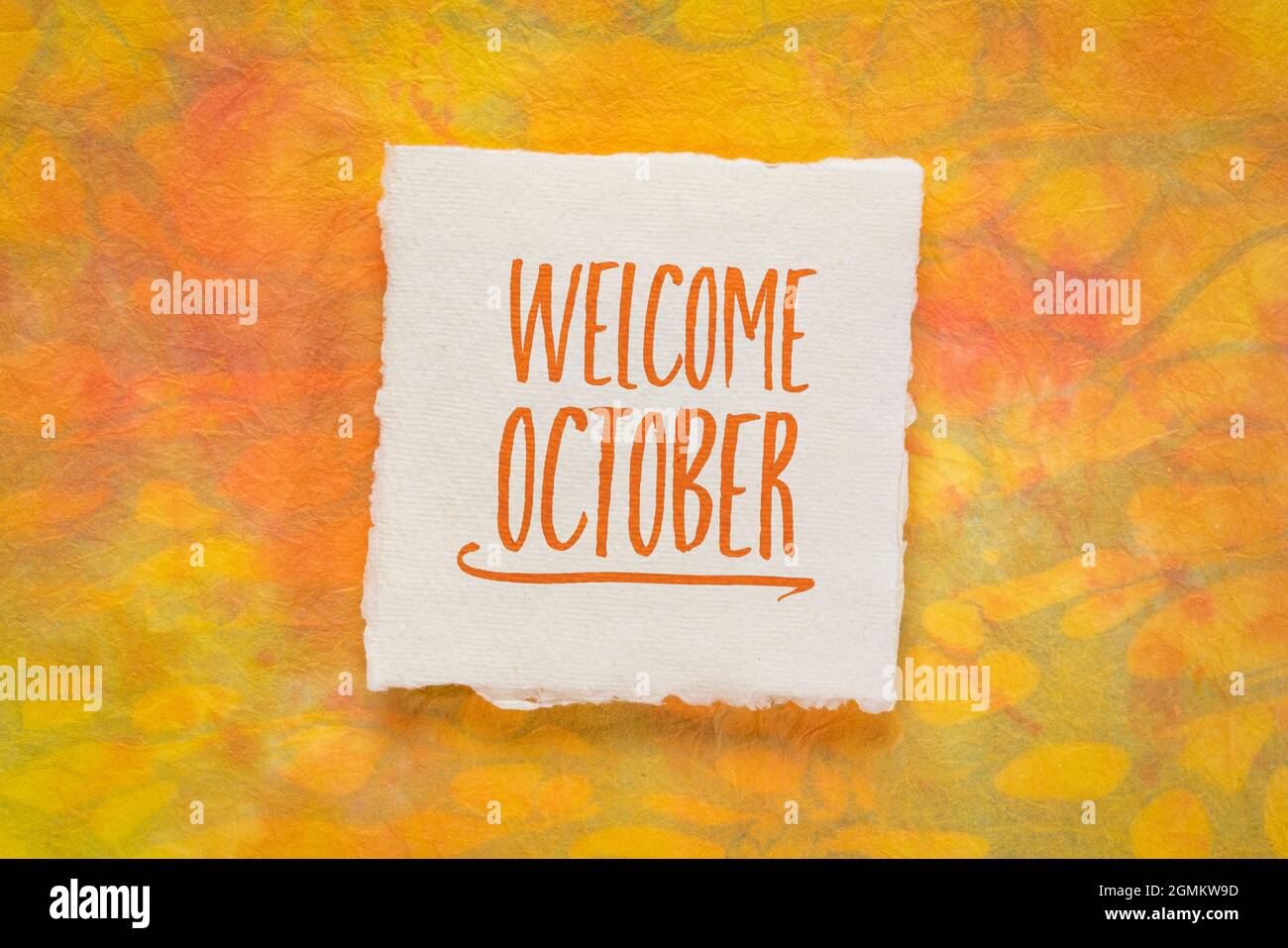 Begrüßungsgruß im Oktober - Handschrift auf einem handgefertigten Stoffpapier gegen Marmorpapier, Kalenderkonzept Stockfoto