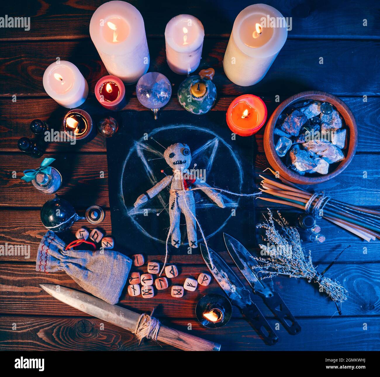 Voodoo Puppe auf dem Tisch in Pentagramma und magischen Attributen, Draufsicht. Stockfoto