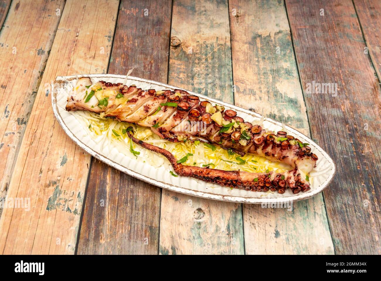 Fettes Tentakel von gegrilltem Tintenfisch mit Knoblauch, Petersilie, Olivenöl Stockfoto