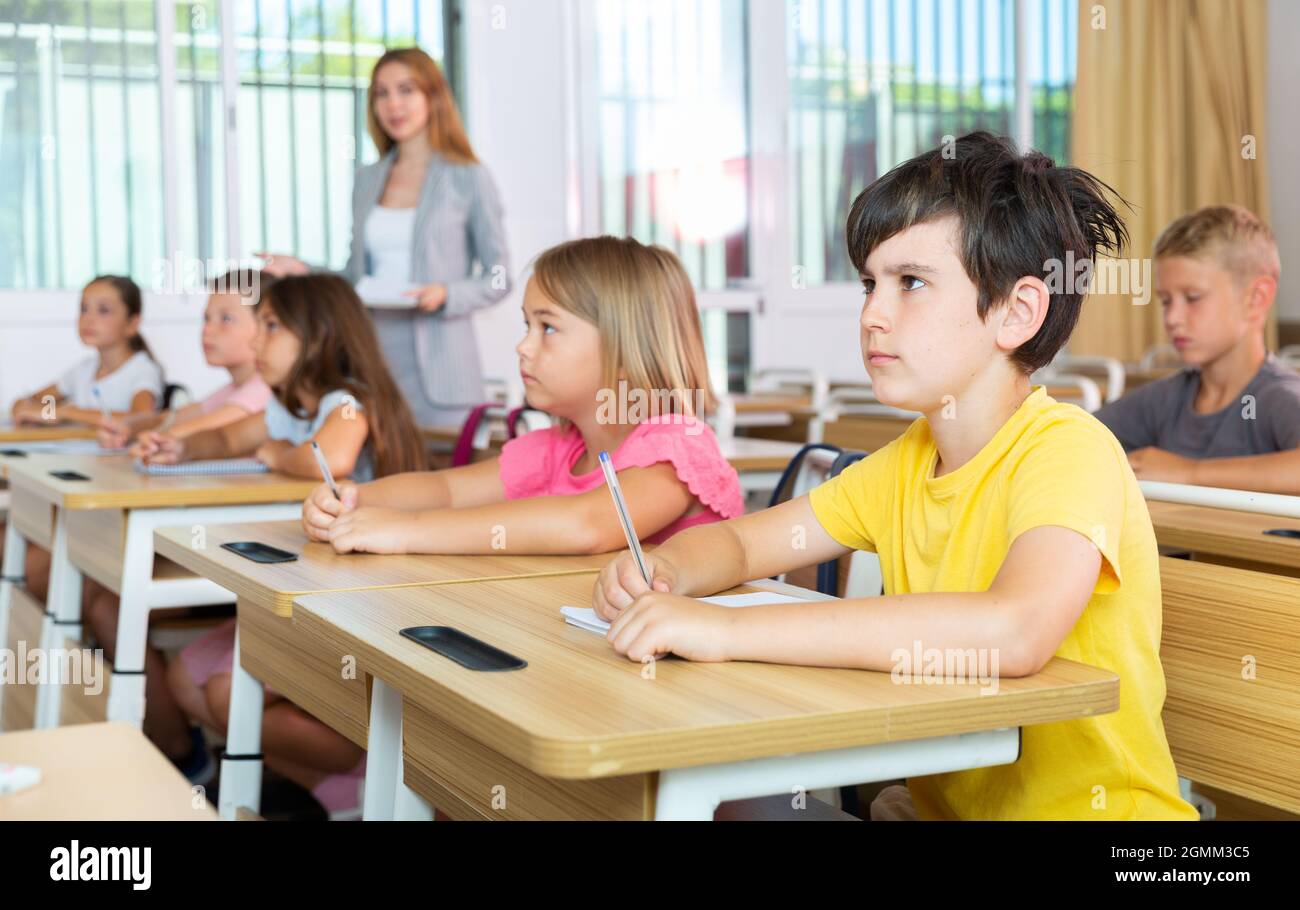 Fleißiger Jugendlicher, der mit Klassenkameraden in der Schule studiert Stockfoto