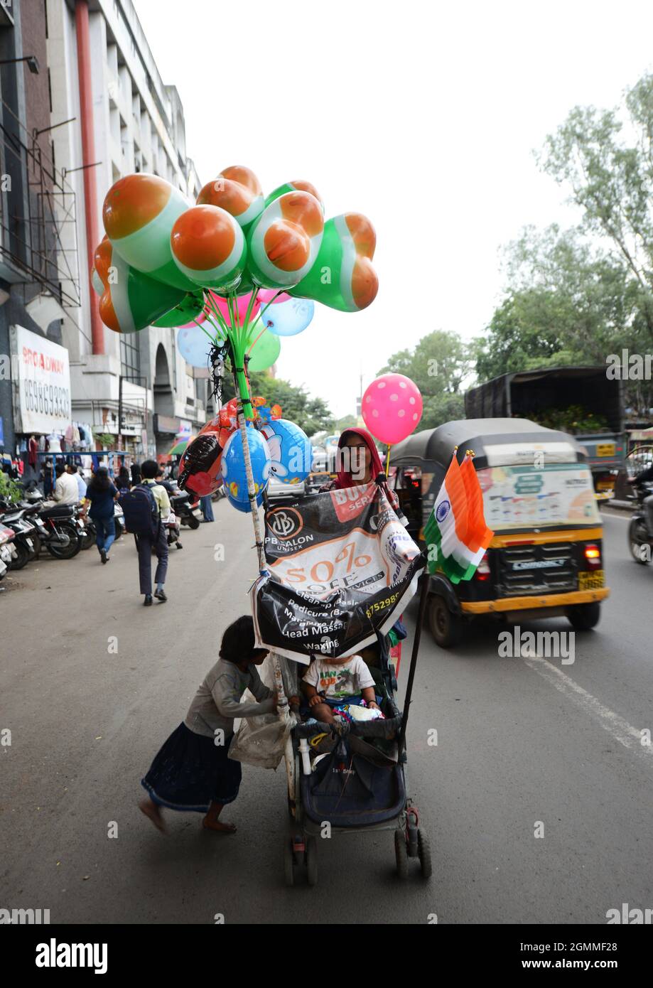 Eine indische Frau, die Luftballons mit indianischer Flagge für die Feierlichkeiten zum Unabhängigkeitstag in Pune, Indien, verkauft. Stockfoto