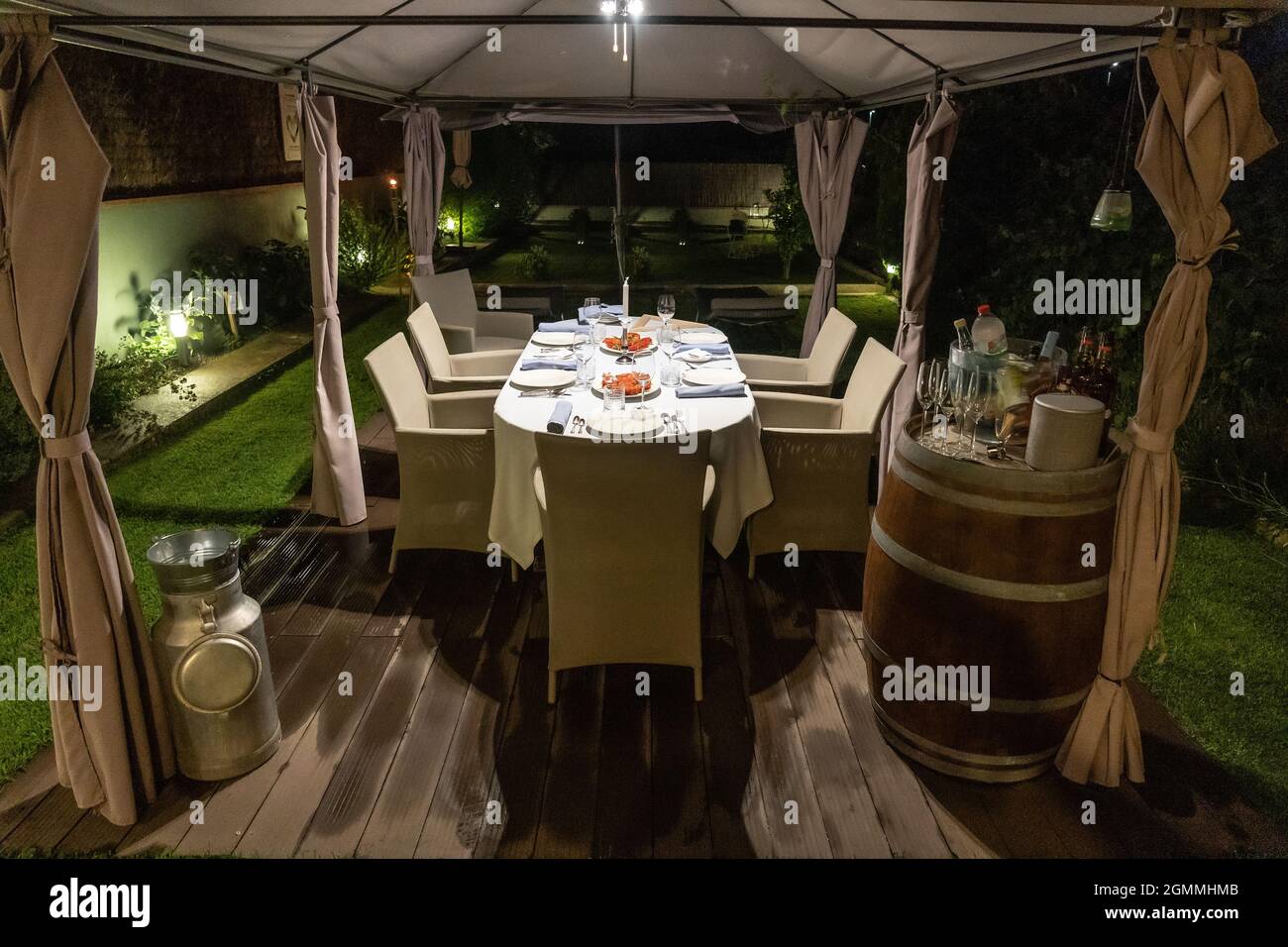 Esstisch mit schönen Dekorationen, Geschirr und einem Tomatensalat in der Mitte des Abends Stockfoto