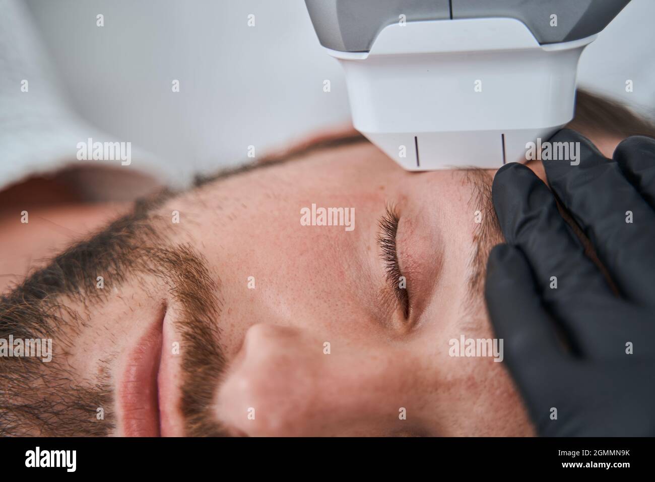 Junger Mann, der sich der hochintensiven fokussierten Ultraschallbehandlung unterziehen wird Stockfoto