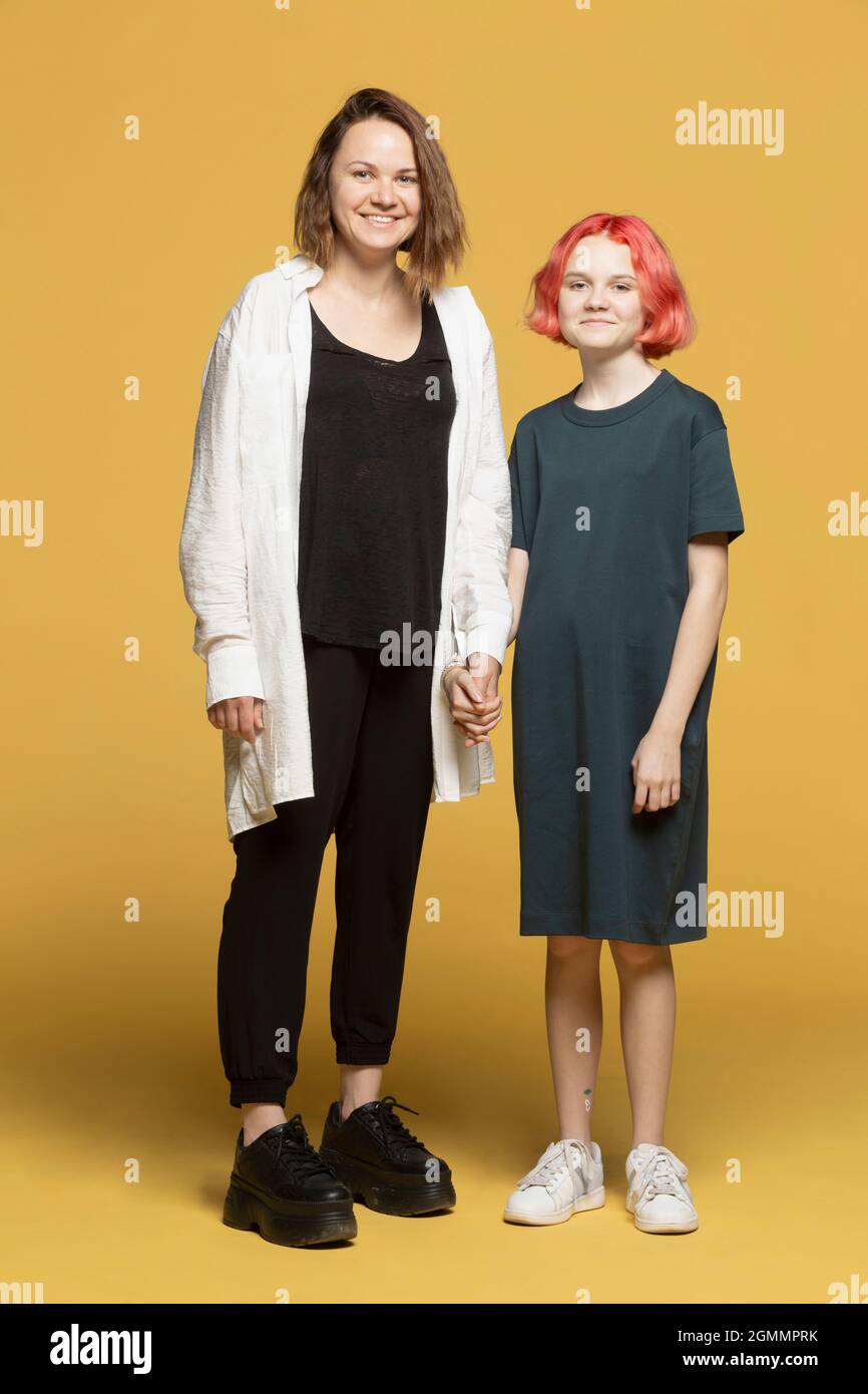 Portrait glückliche Mutter und Tochter auf gelbem Hintergrund Stockfoto