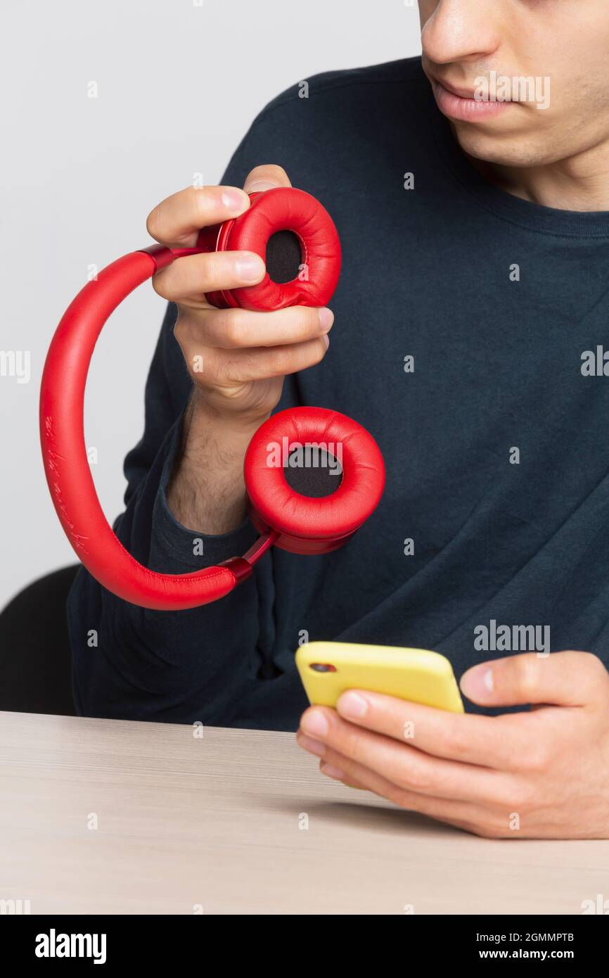 Mann mit Smartphone und kabellosen Kopfhörern Stockfoto