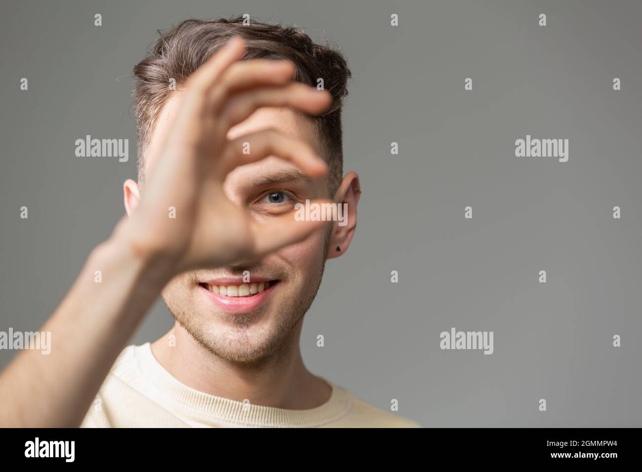 Portrait glücklicher junger Mann gestikuliert Stockfoto