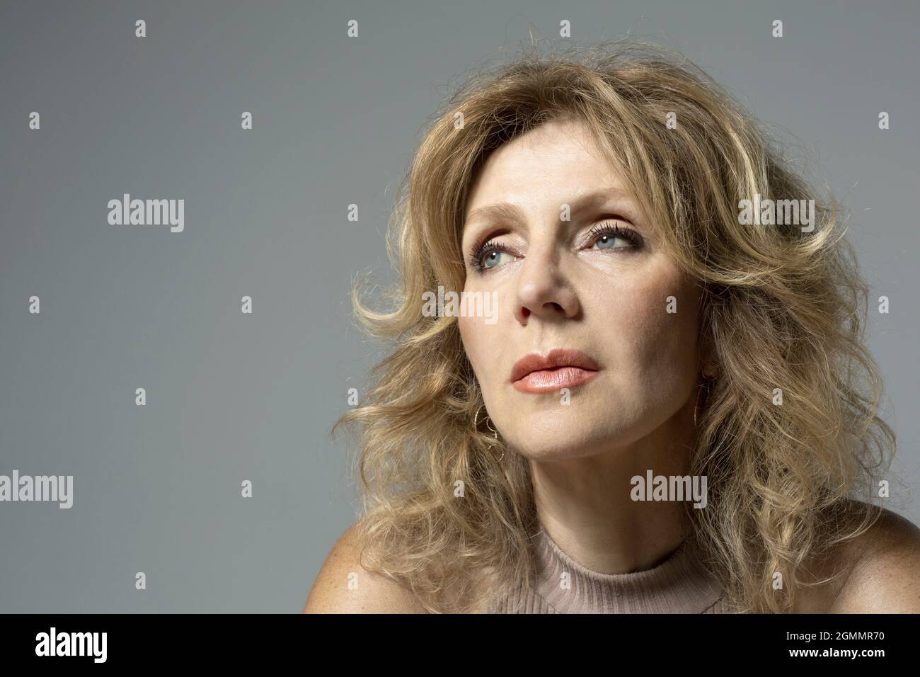 Portrait nachdenkliche Frau, die auf grauem Hintergrund wegschaut Stockfoto