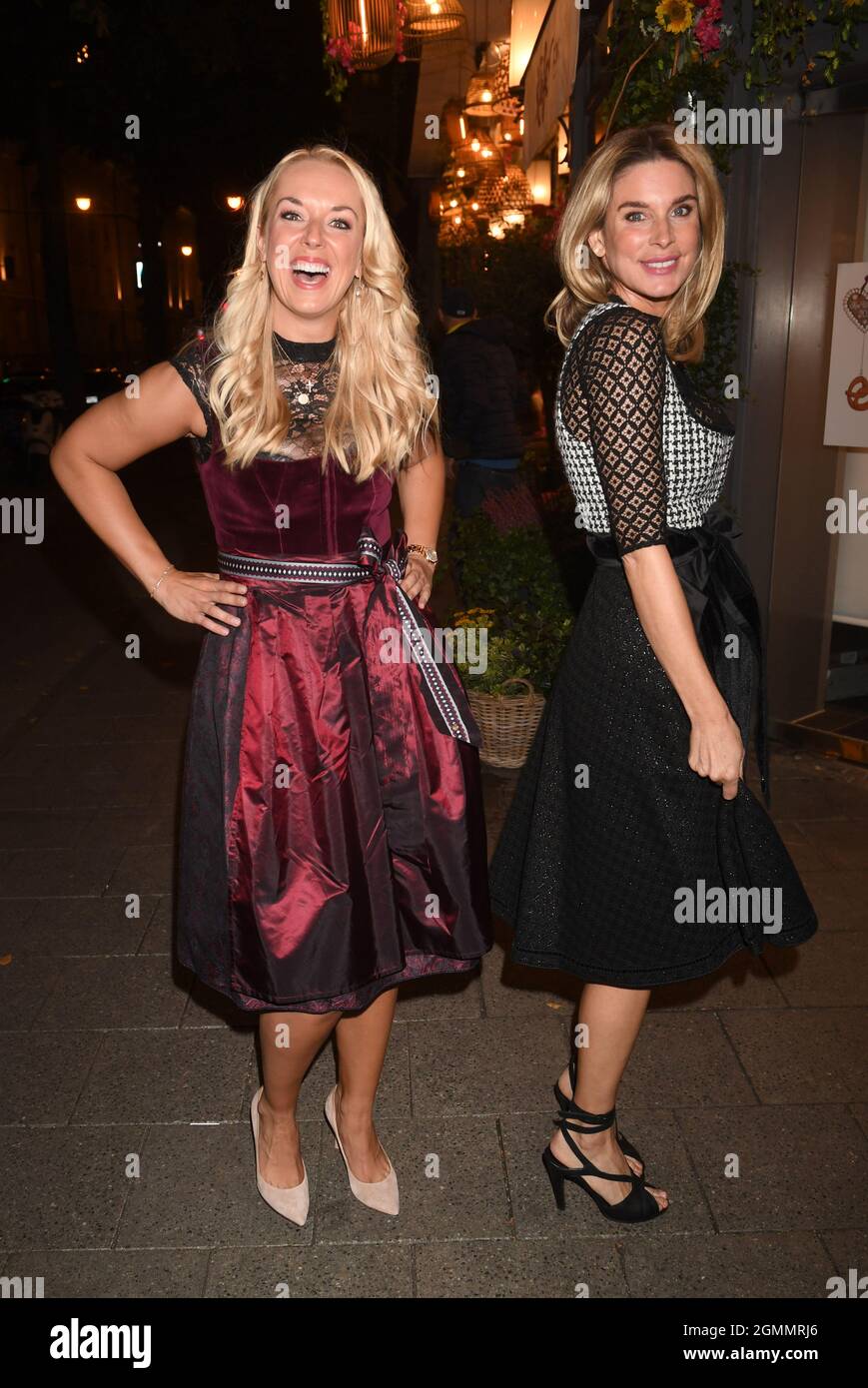 München, Deutschland. September 2021. Tennisspielerin Sabine Lisicki (l.) und Schauspielerin Claudelle Deckert zeigen beim Almauftrieb vor der Käfer Schänke. Auch in diesem Jahr gibt es kein Oktoberfest aufgrund der Corona-Pandemie. Dennoch wird es in der Stadt Feste geben. Quelle: Felix Hörhager/dpa/Alamy Live News Stockfoto