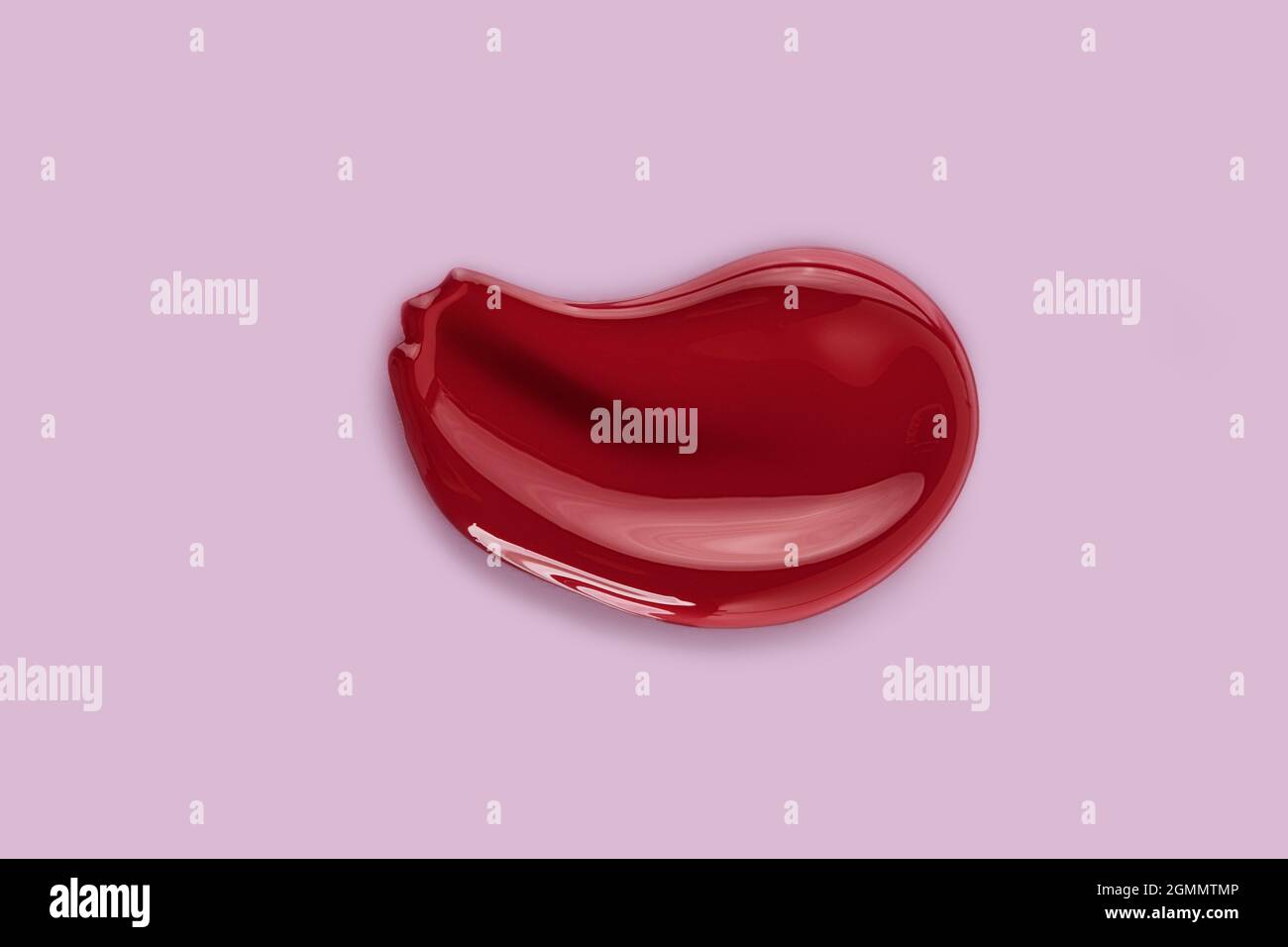 Rotes Make-up schmiert die Textur des Lipgloss Balms. Isoliert auf rosa Hintergrund. Stockfoto
